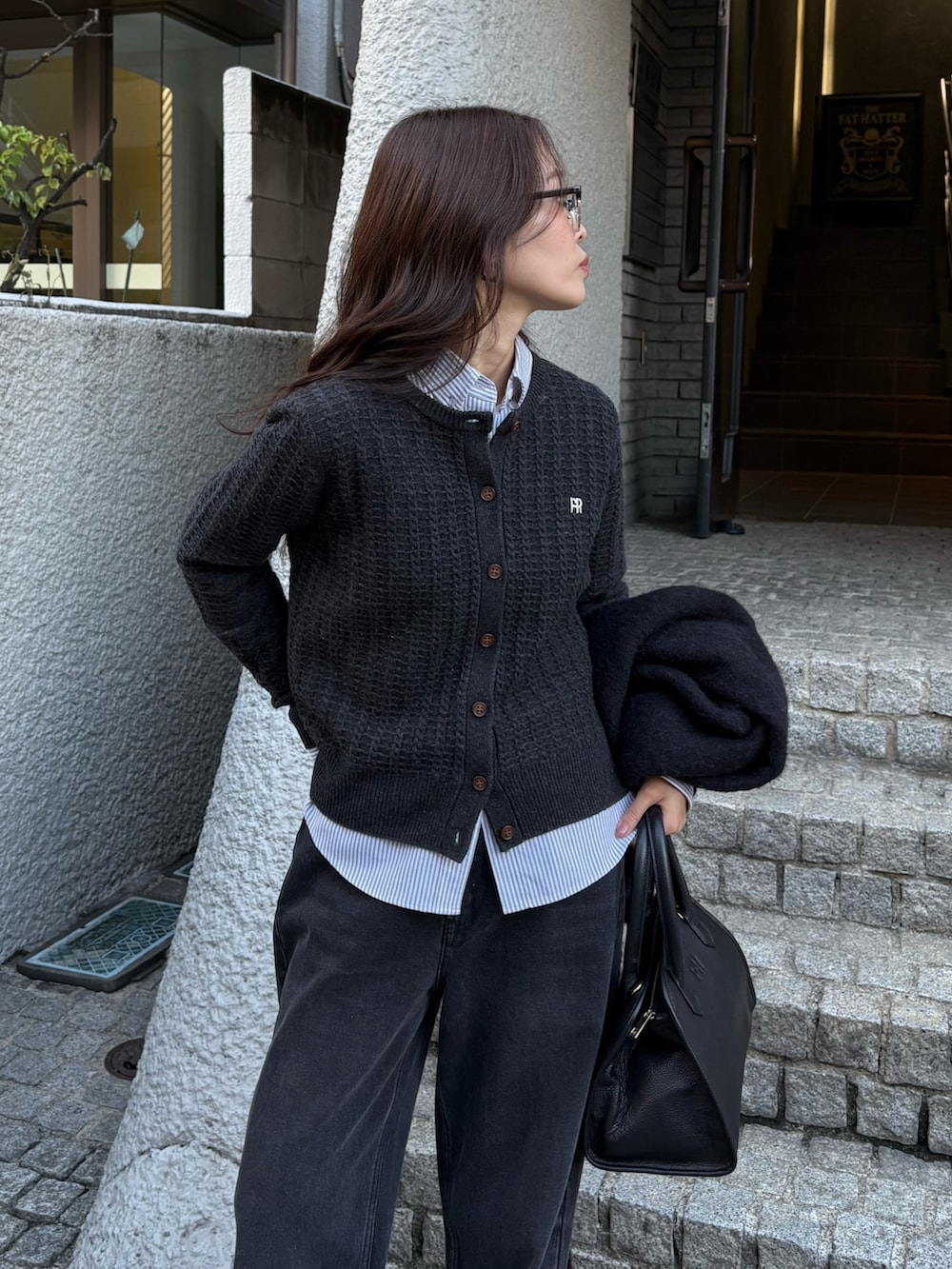 グレー系のニット/セーター、ブラック系のデニムパンツを着用したレディースの秋コーディネートの3枚目の写真