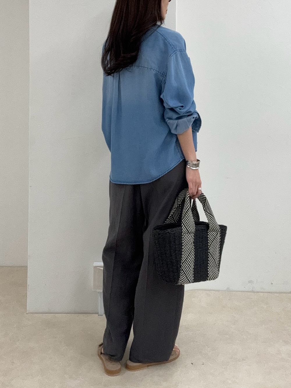 ブルー系のシャツ/ブラウス、グレー系のスラックスを着用したレディースの春コーディネートの3枚目の写真