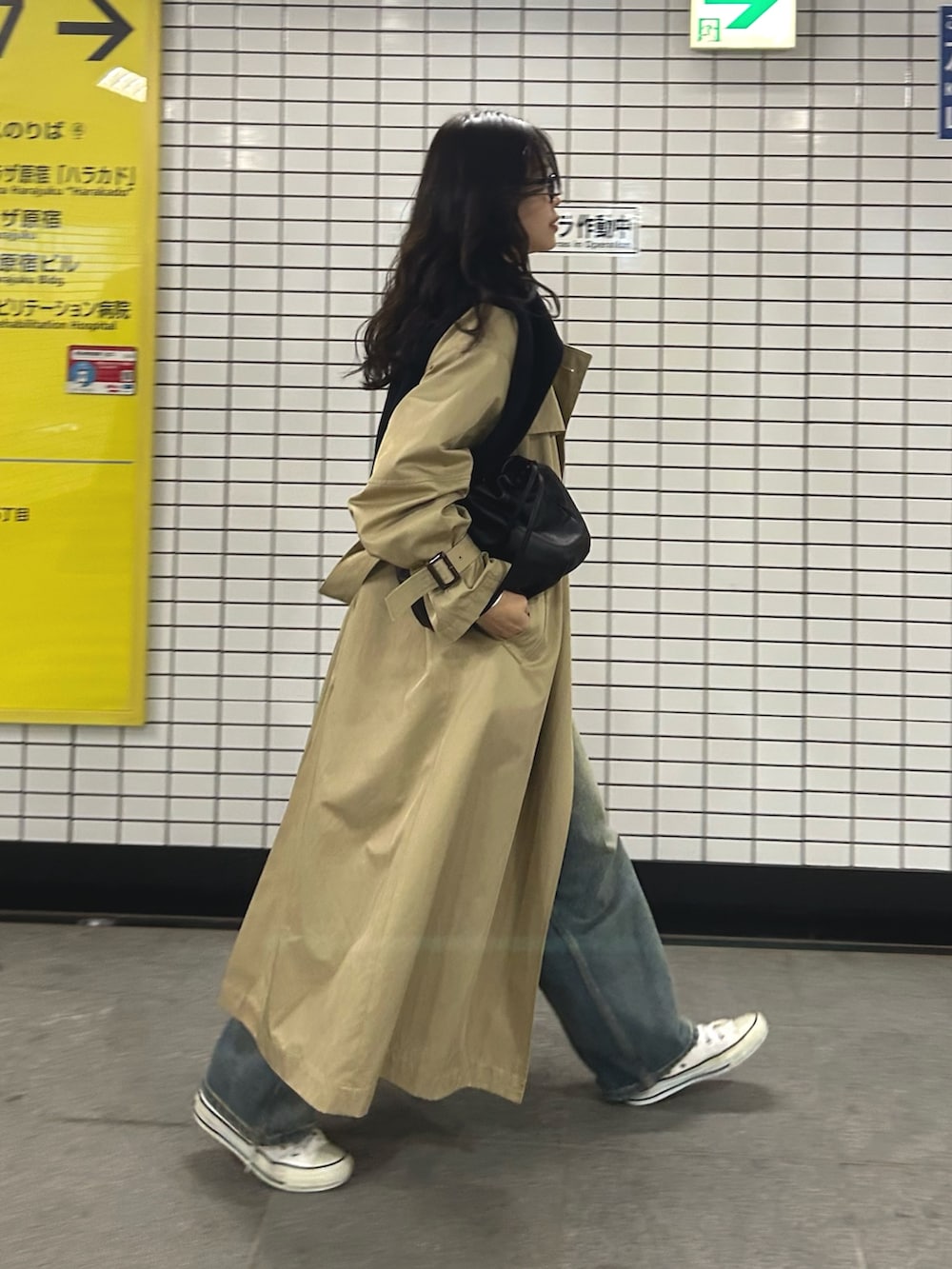 ベージュ系のトレンチコート、ブルー系のデニムパンツ、ブラック系のショルダーバッグを着用したレディースの冬コーディネートの6枚目の写真