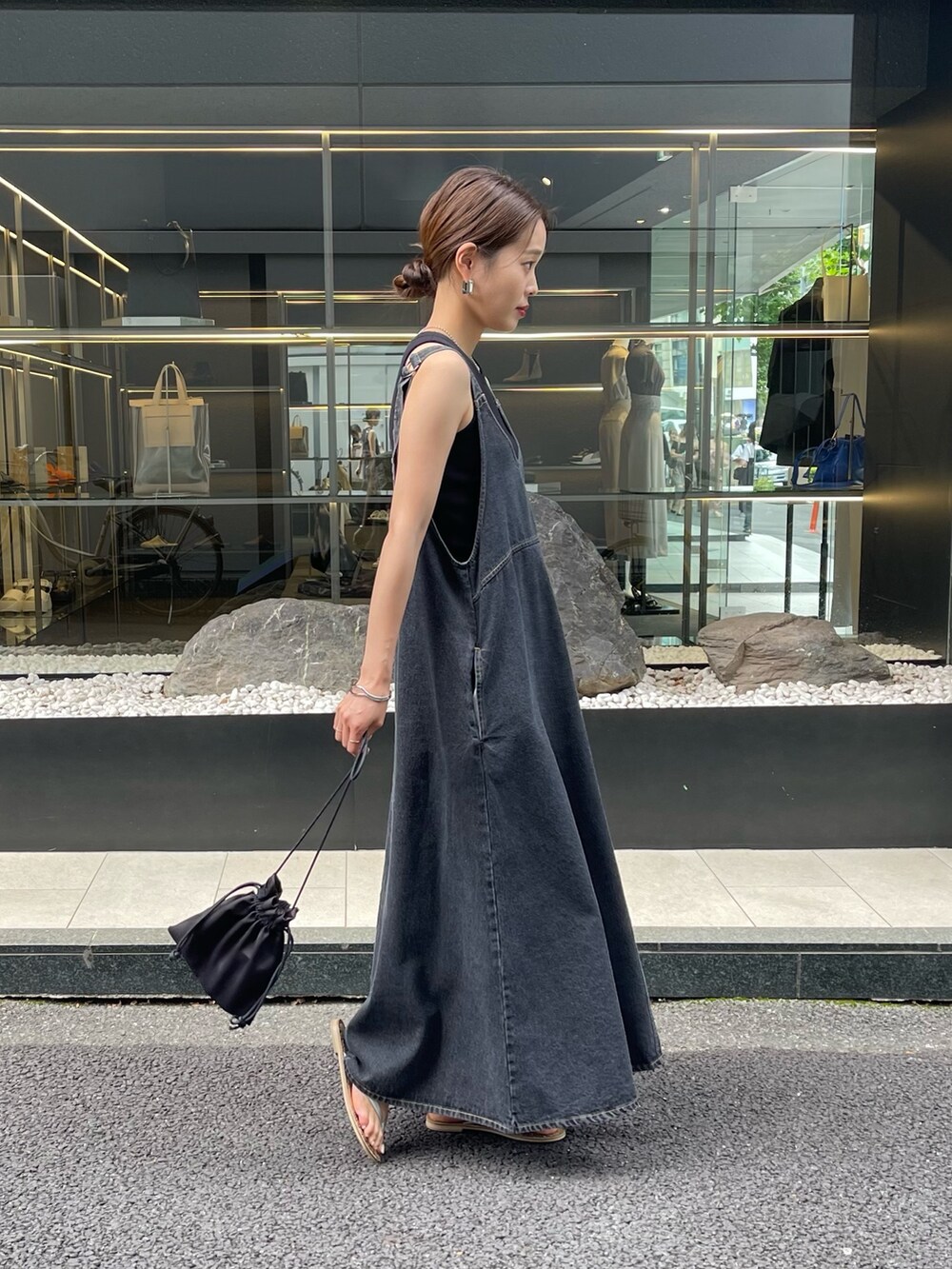 ブラック系のワンピース、ブラック系のショルダーバッグを着用したレディースの夏コーディネートの2枚目の写真