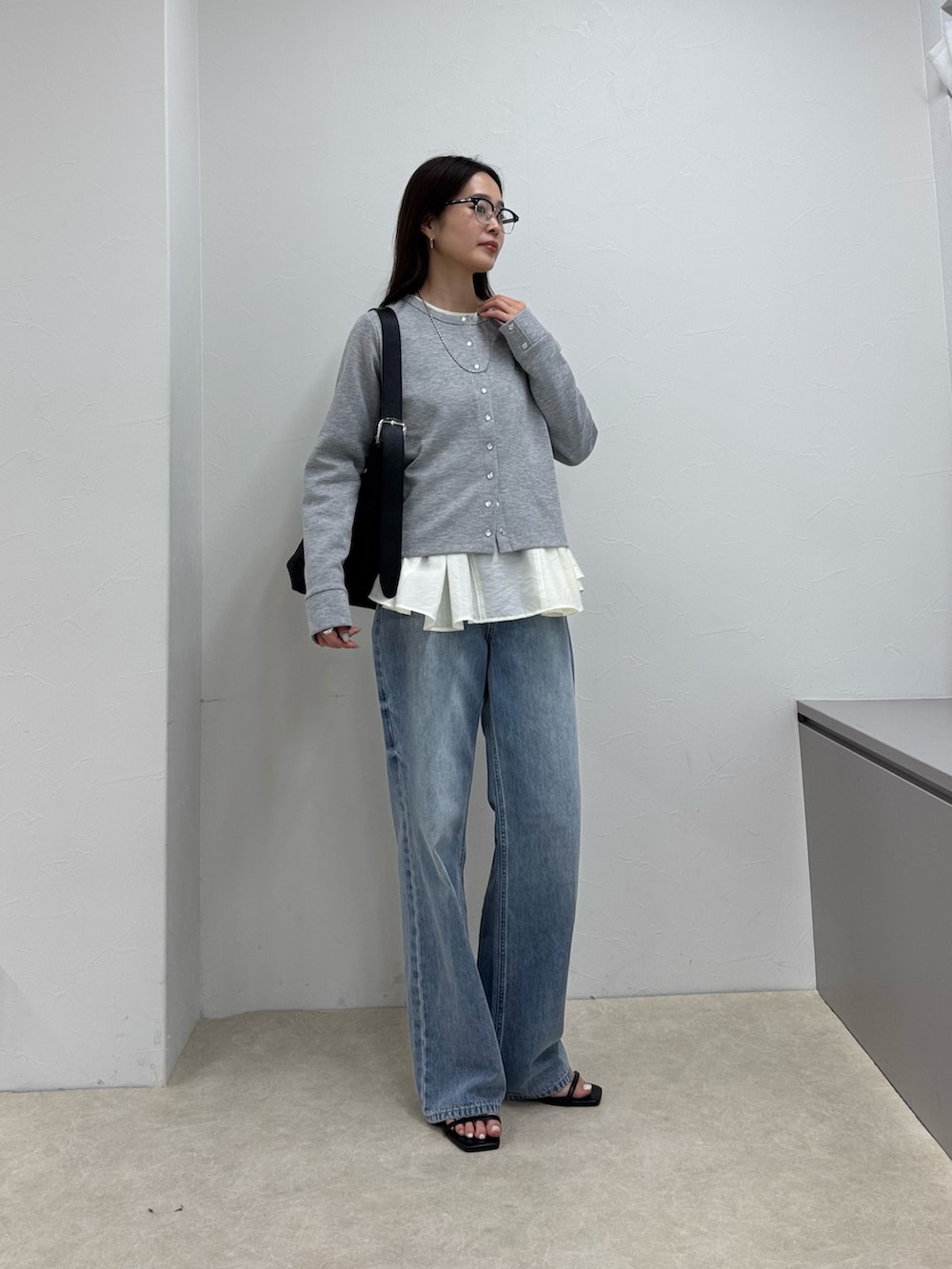 グレー系のカーディガン/ボレロ、ブルー系のデニムパンツ、ホワイト系のシャツ/ブラウスを着用したレディースの春コーディネートの2枚目の写真