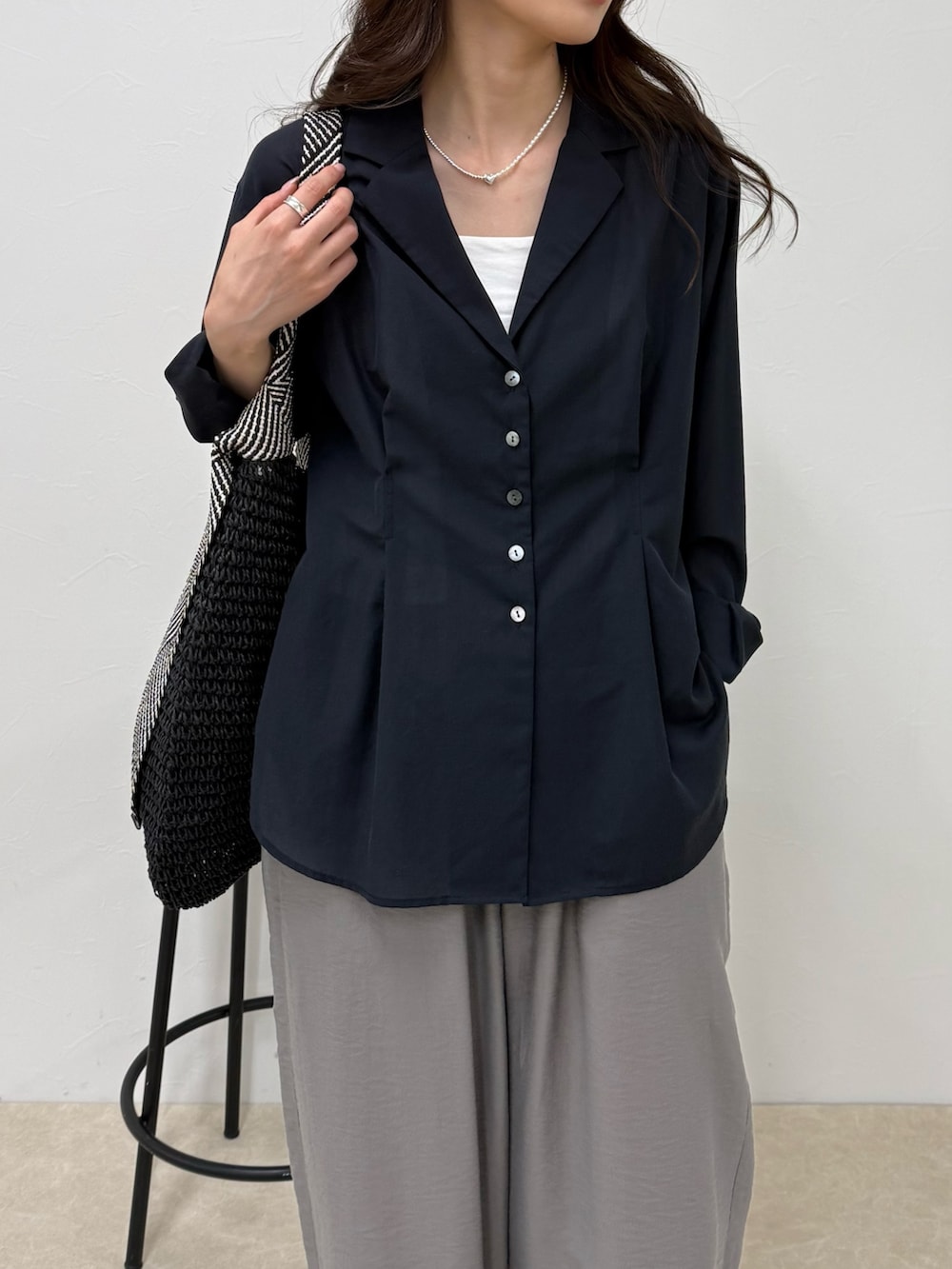 ブルー系のシャツ/ブラウス、グレー系のその他パンツ、ブラック系のトートバッグを着用したレディースの春コーディネートの6枚目の写真