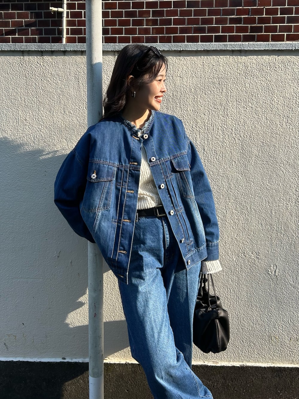 ブルー系のデニムジャケット、ホワイト系のTシャツ/カットソー、ブルー系のデニムパンツを着用したレディースの春コーディネートの4枚目の写真