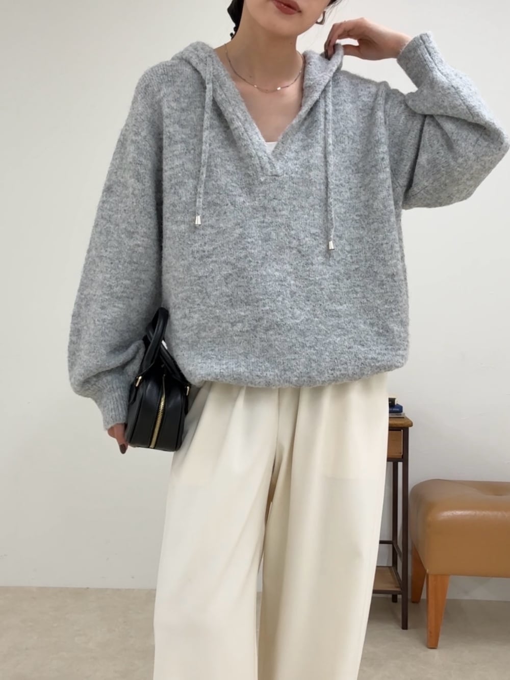 グレー系のニット/セーター、ホワイト系のその他パンツ、ブラック系のショルダーバッグを着用したレディースの夏コーディネートの3枚目の写真