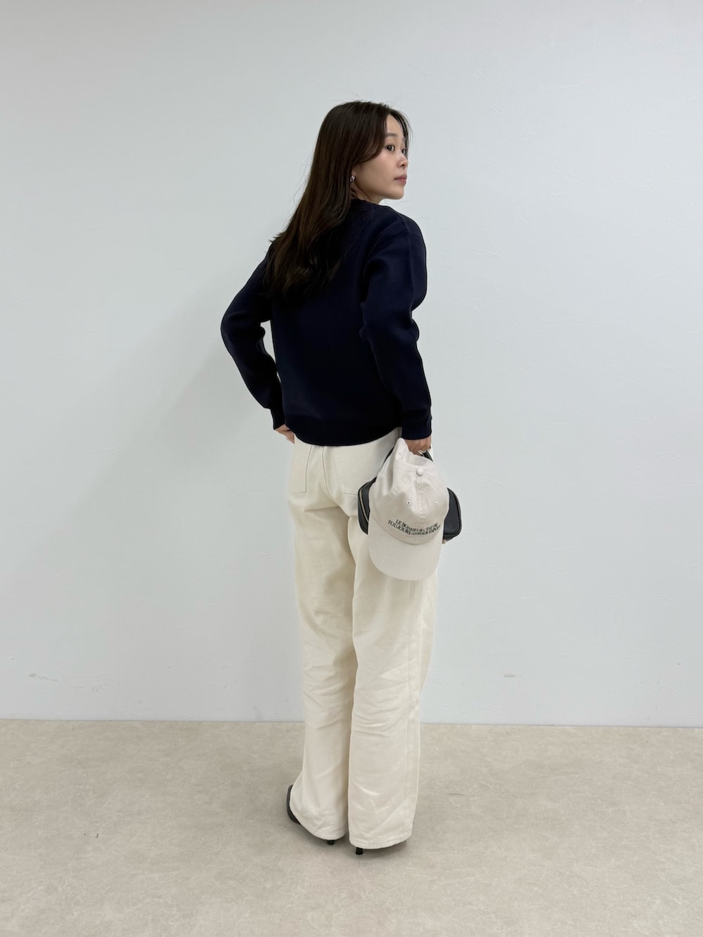 ブルー系のニット/セーター、ホワイト系のデニムパンツ、ホワイト系のキャップを着用したレディースの夏コーディネートの3枚目の写真