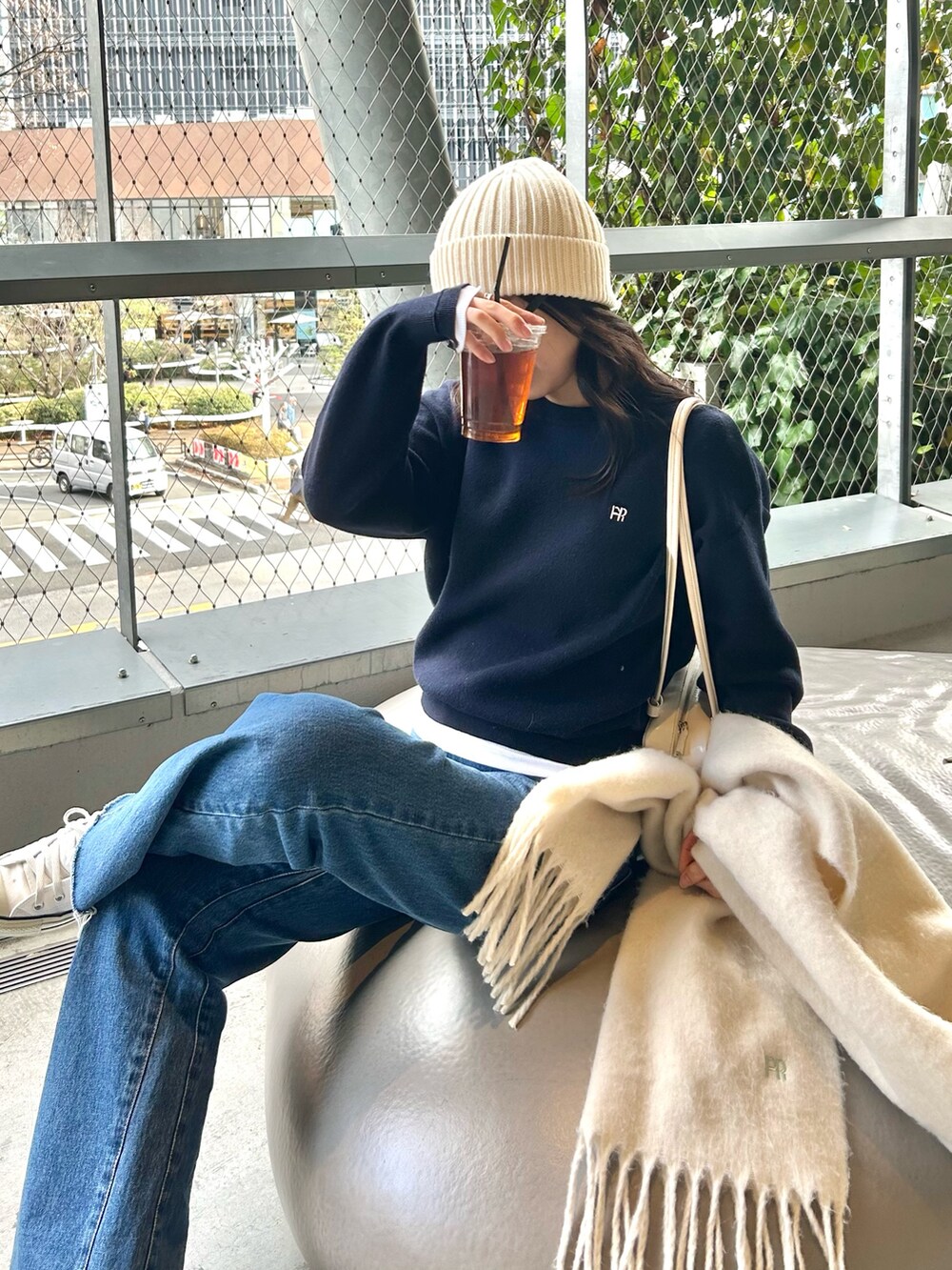 ブルー系のニット/セーター、ブルー系のデニムパンツ、ホワイト系のストール/ショールを着用したレディースの冬コーディネートの3枚目の写真