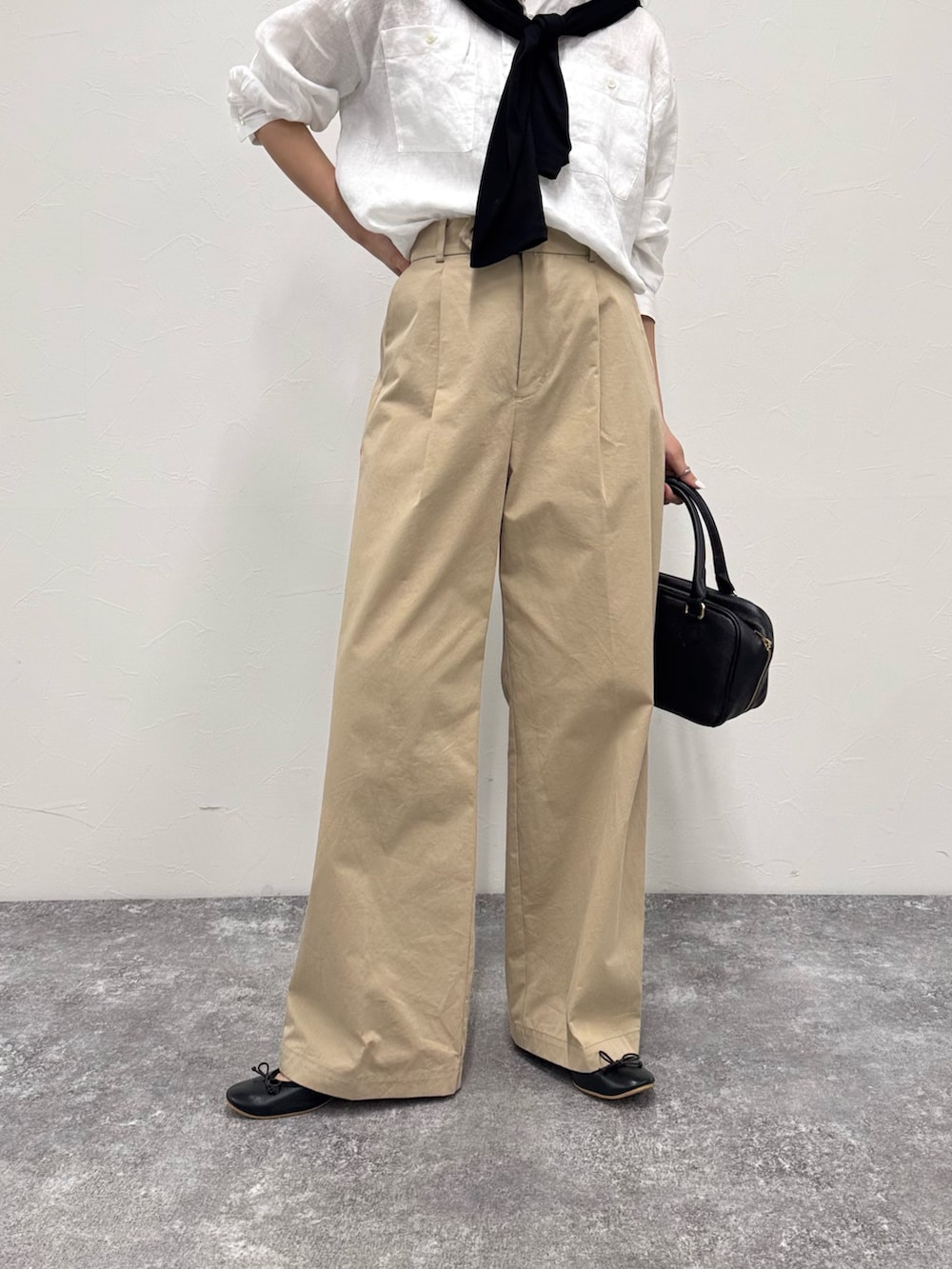 ホワイト系のシャツ/ブラウス、ベージュ系のチノパンツ、ブラック系のショルダーバッグを着用したレディースの春コーディネートの4枚目の写真