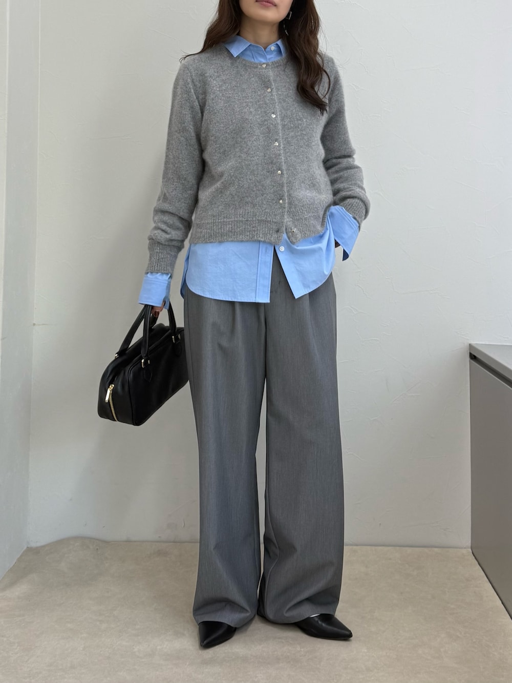 グレー系のカーディガン/ボレロ、ブルー系のシャツ/ブラウス、ブラック系のボストンバッグを着用したレディースの秋コーディネートの3枚目の写真