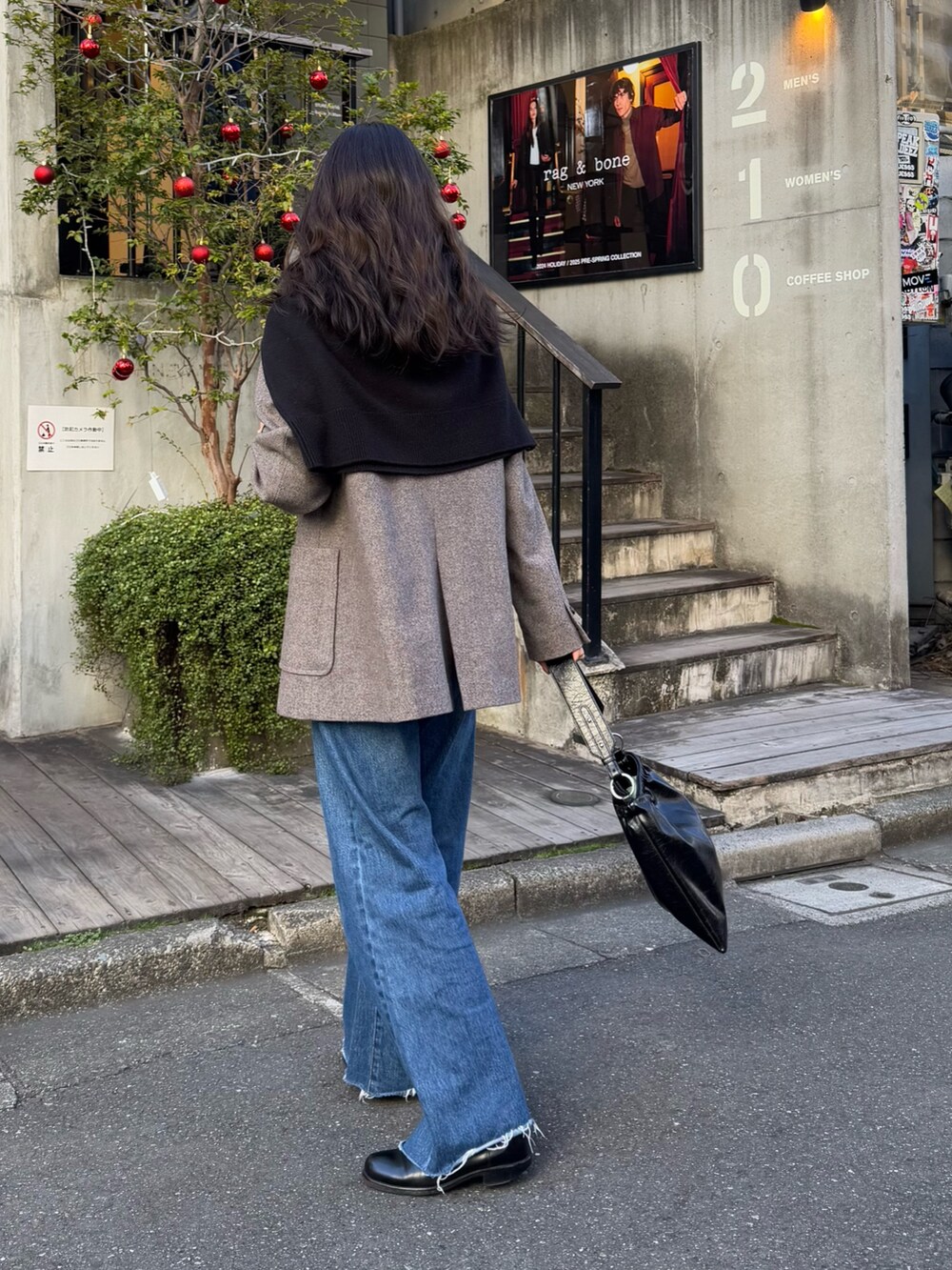 ブルー系のデニムパンツ、ブラウン系のテーラードジャケット、ブラック系のニット/セーターを着用したレディースの冬コーディネートの3枚目の写真