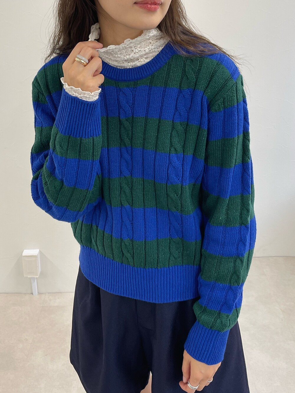 ブルー系のニット/セーター、ブルー系のその他パンツ、ホワイト系のTシャツ/カットソーを着用したレディースの冬コーディネートの2枚目の写真