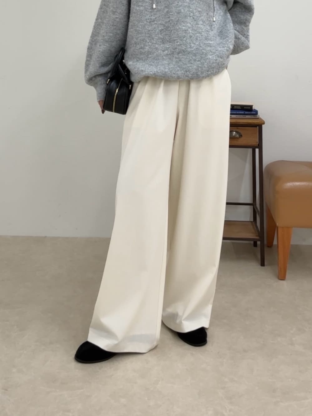 グレー系のニット/セーター、ホワイト系のその他パンツ、ブラック系のショルダーバッグを着用したレディースの夏コーディネートの5枚目の写真