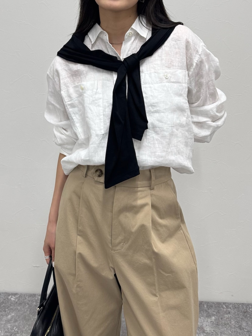 ホワイト系のシャツ/ブラウス、ベージュ系のチノパンツ、ブラック系のショルダーバッグを着用したレディースの春コーディネートの3枚目の写真