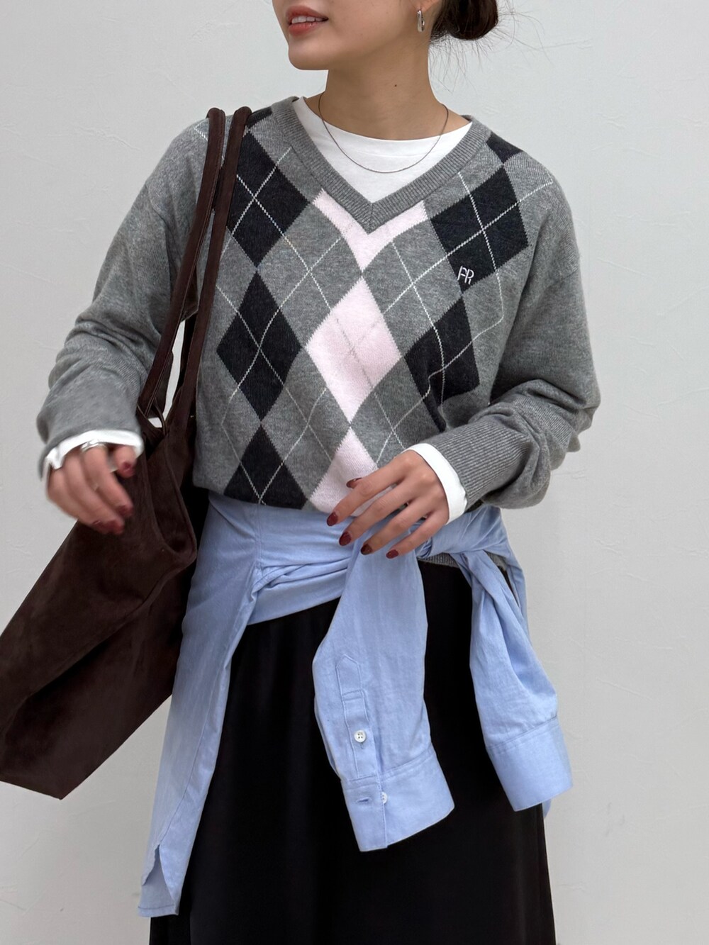 グレー系のニット/セーター、ブラック系のスカートを着用したレディースの冬コーディネートの6枚目の写真