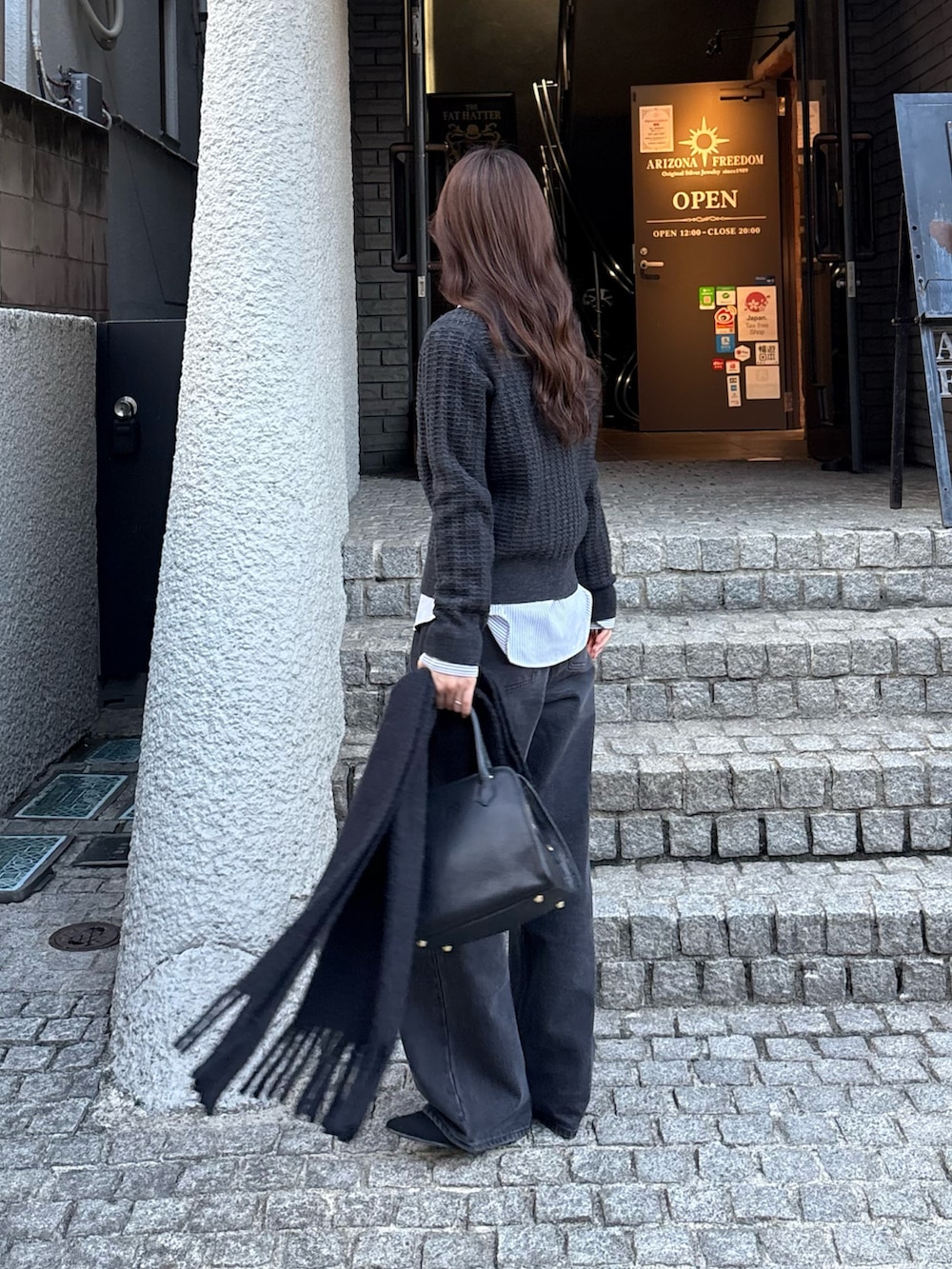 グレー系のニット/セーター、ブラック系のデニムパンツを着用したレディースの秋コーディネートの4枚目の写真