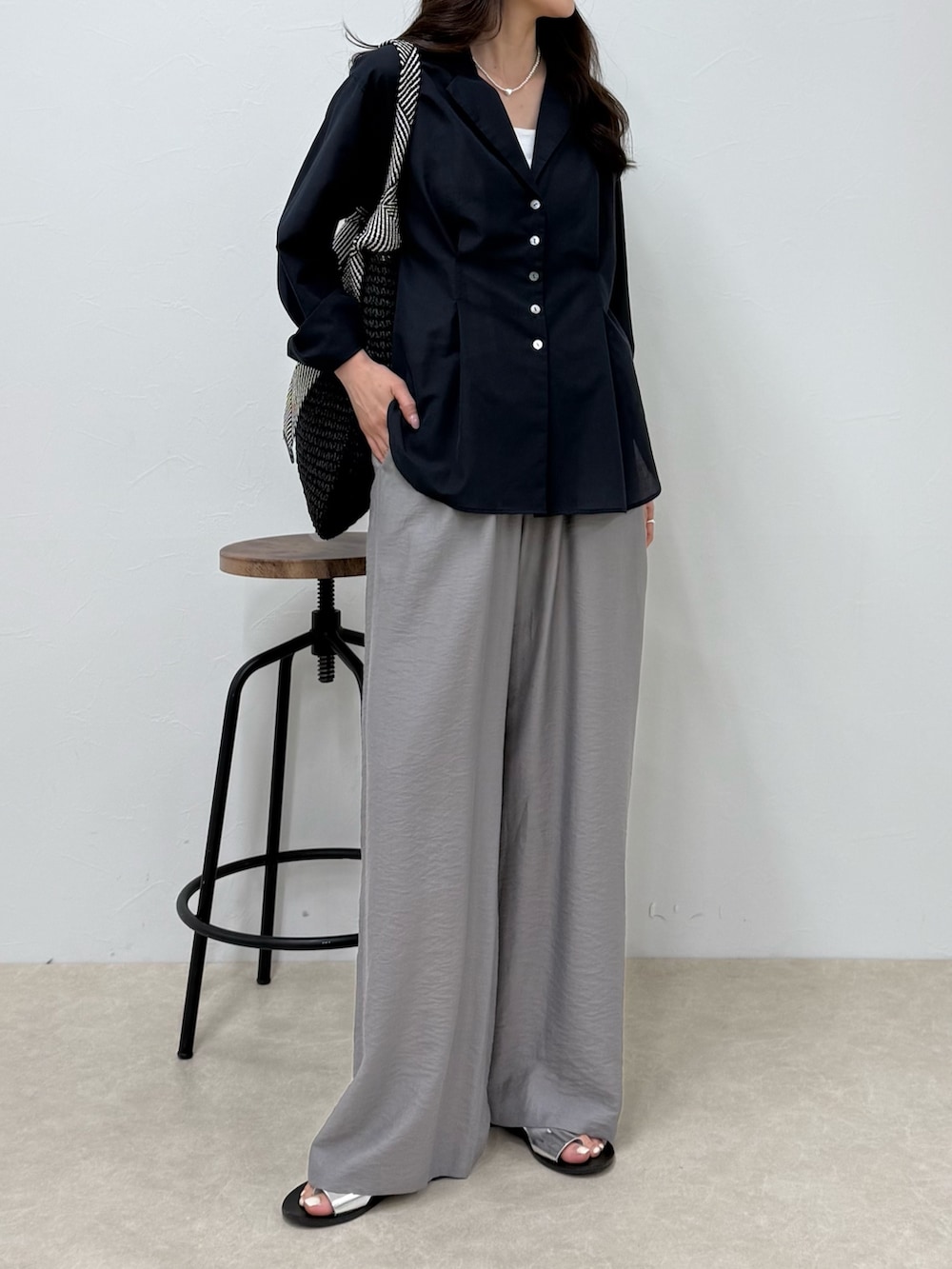 ブルー系のシャツ/ブラウス、グレー系のその他パンツ、ブラック系のトートバッグを着用したレディースの春コーディネートの4枚目の写真