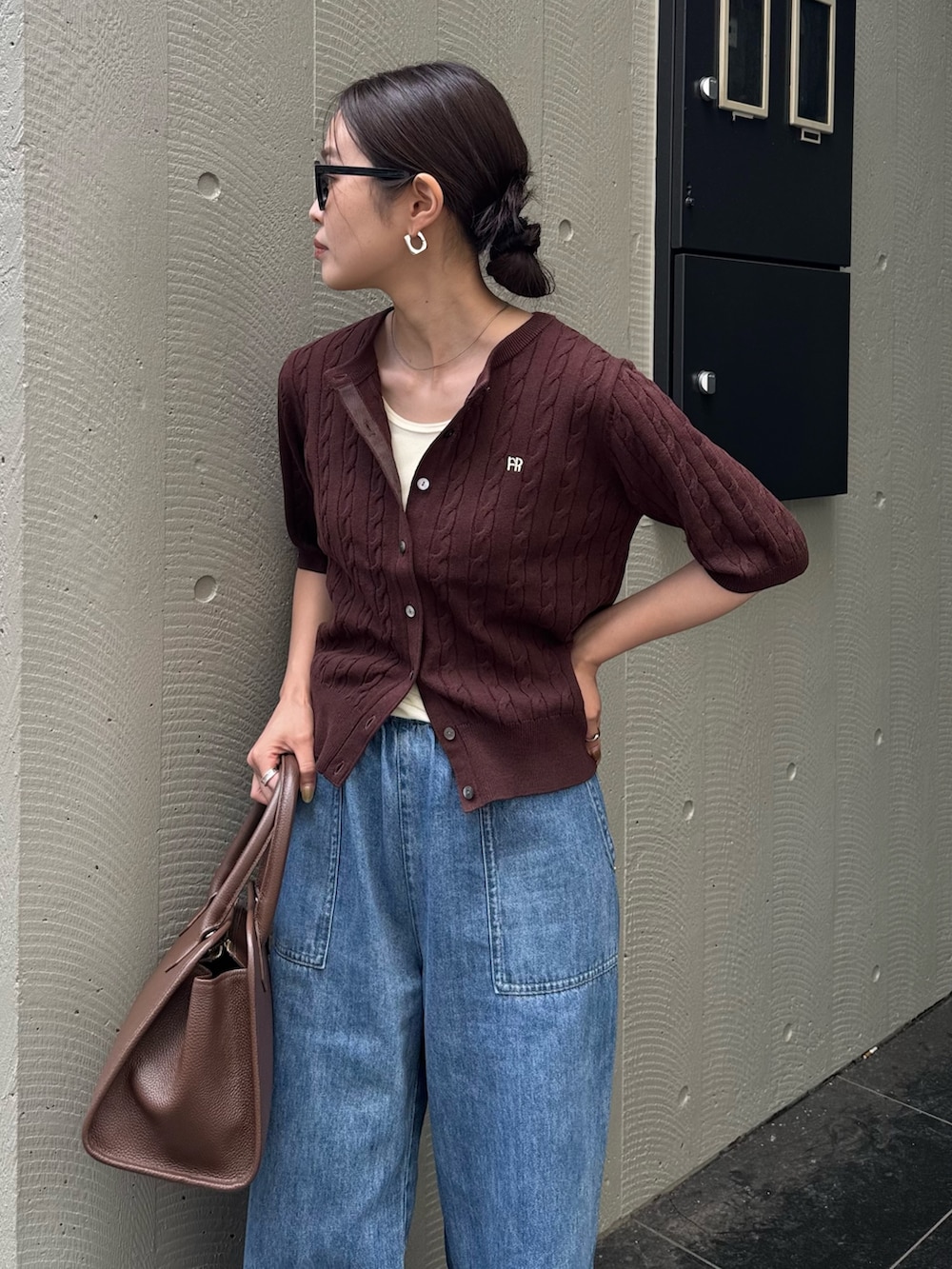 ブルー系のデニムパンツ、ブラウン系のショルダーバッグ、ブラウン系のカーディガン/ボレロを着用したレディースの夏コーディネートの2枚目の写真