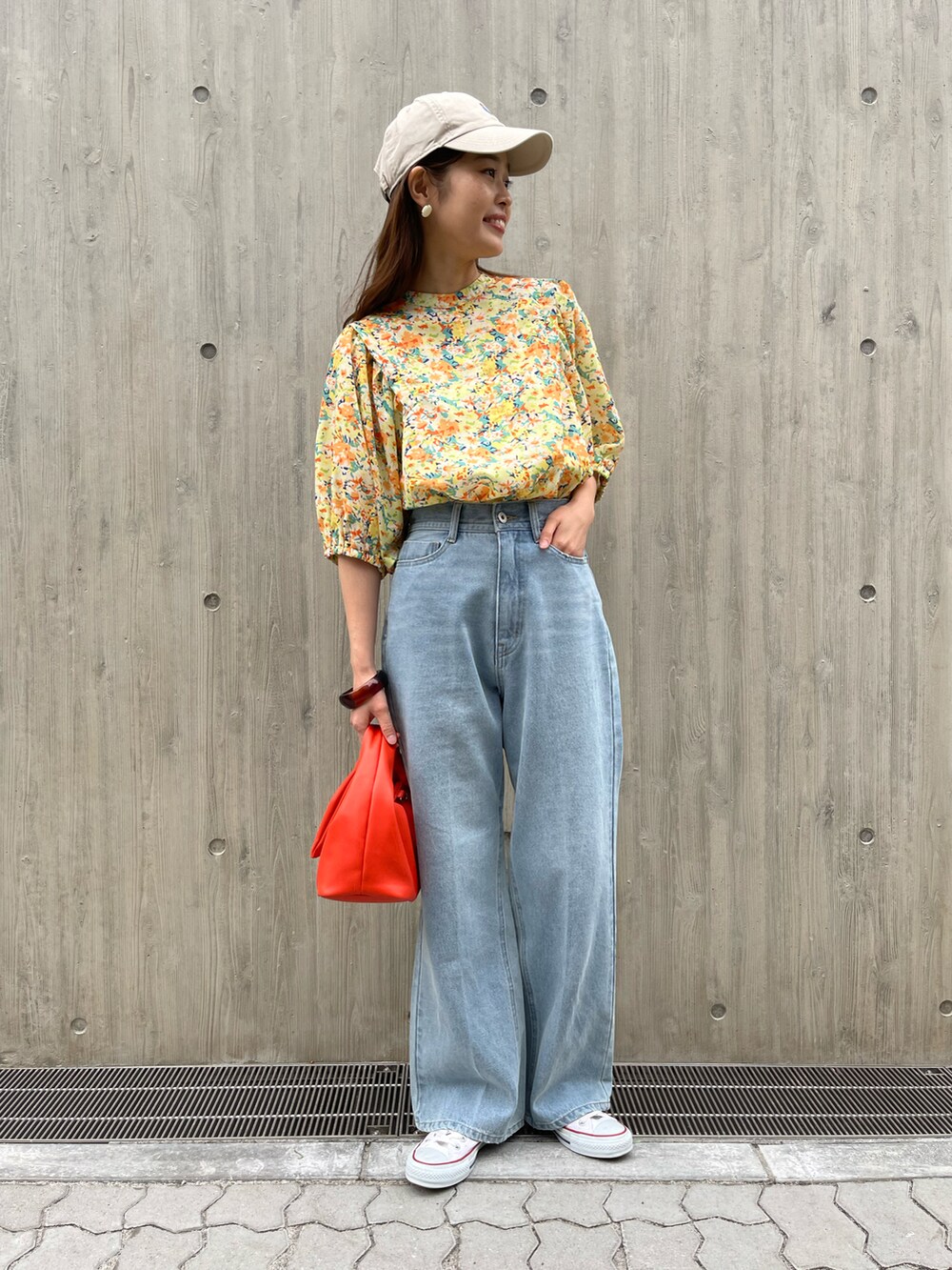 ブルー系のデニムパンツ、イエロー系のシャツ/ブラウス、オレンジ系のショルダーバッグを着用したレディースの春コーディネートの2枚目の写真