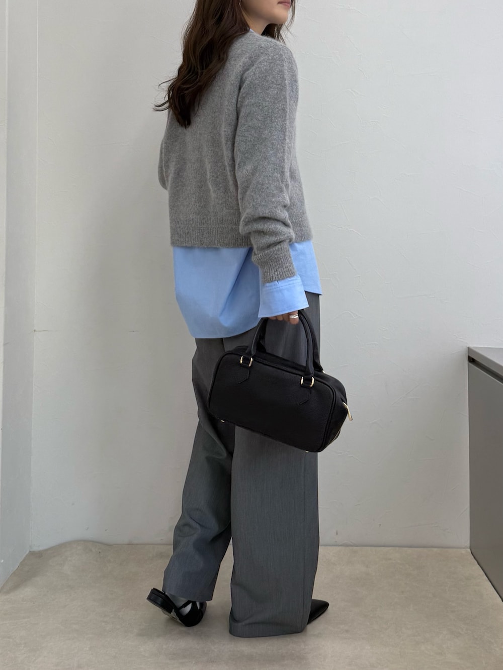 グレー系のカーディガン/ボレロ、ブルー系のシャツ/ブラウス、ブラック系のボストンバッグを着用したレディースの秋コーディネートの4枚目の写真