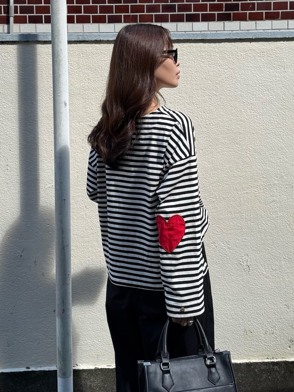 ホワイト系のTシャツ/カットソー、ブラック系のその他パンツ、ブラック系のボストンバッグを着用したレディースの夏コーディネートの5枚目の写真