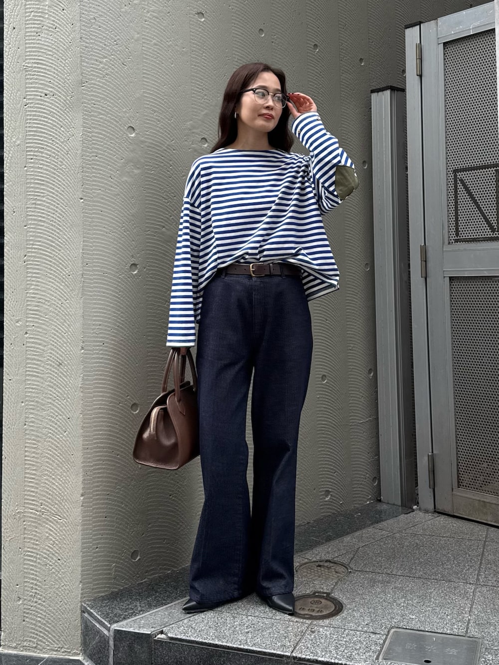 ブルー系のTシャツ/カットソー、ブルー系のデニムパンツ、ブラウン系のショルダーバッグを着用したレディースの夏コーディネートの3枚目の写真