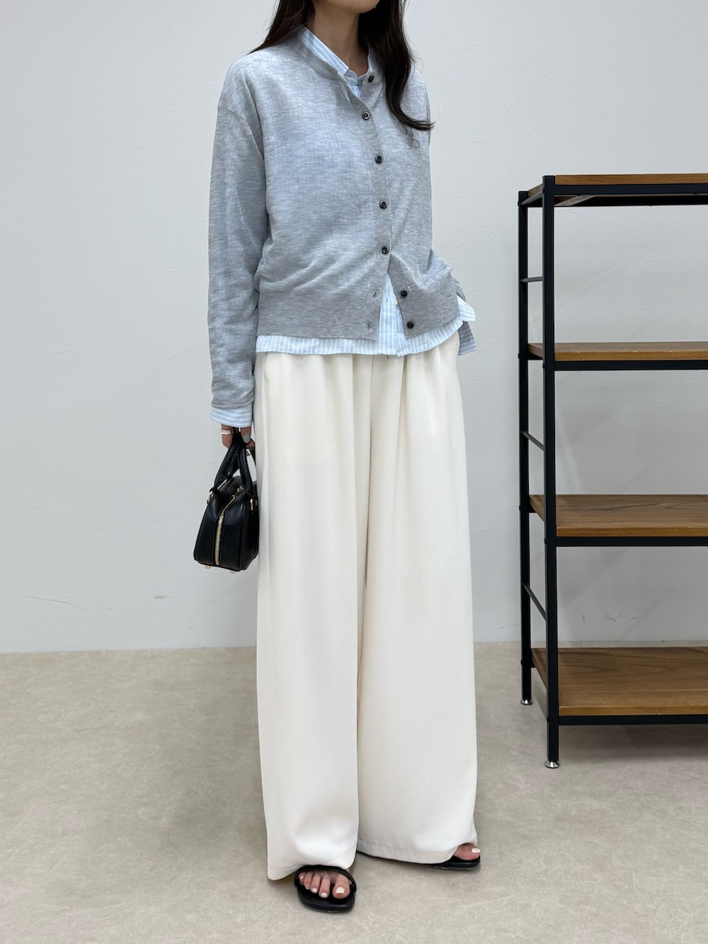 グレー系のカーディガン/ボレロ、ブルー系のシャツ/ブラウス、ホワイト系のその他パンツを着用したレディースの春コーディネートの2枚目の写真