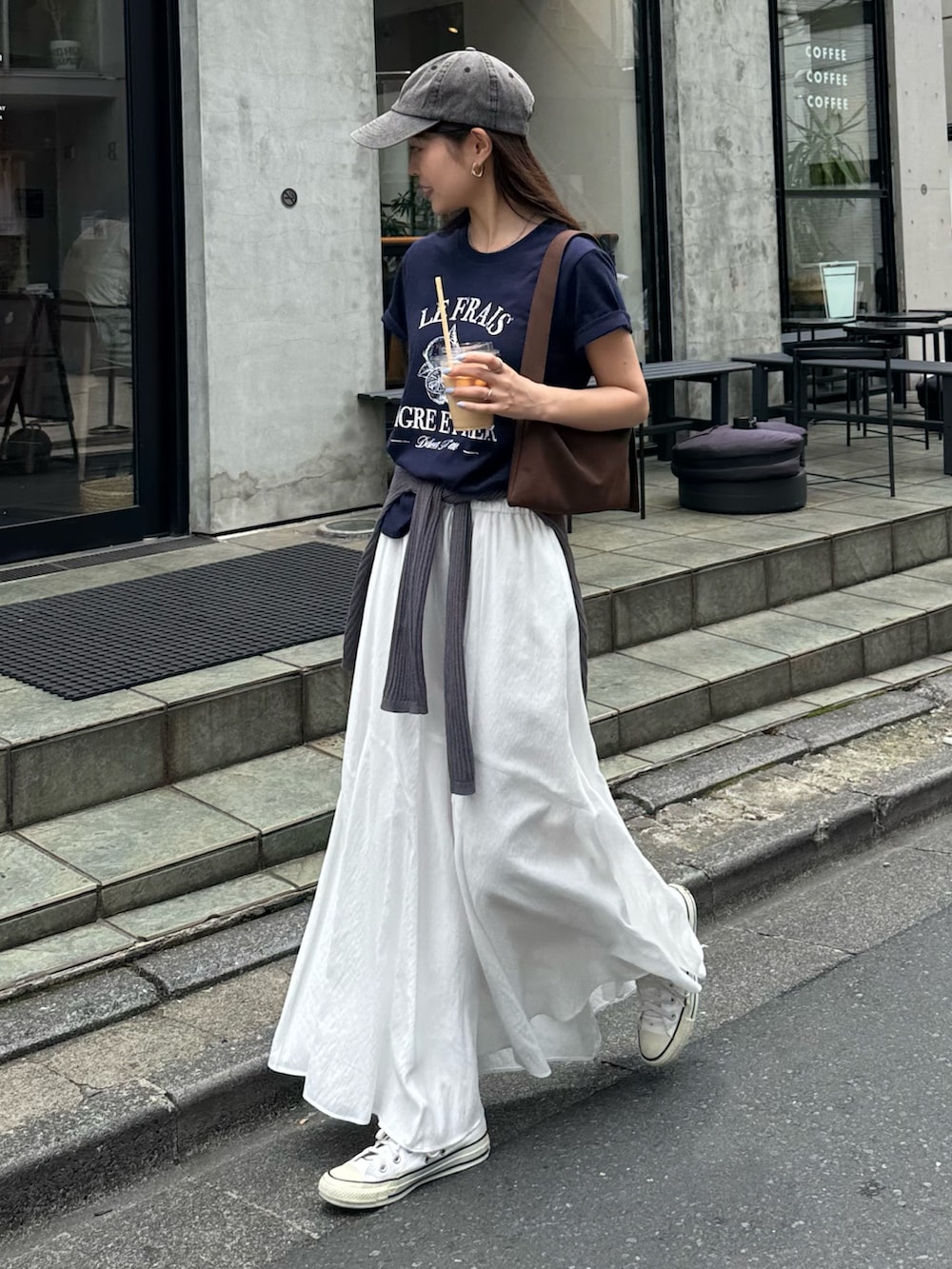ブルー系のTシャツ/カットソー、ホワイト系のスカート、グレー系のキャップを着用したレディースの夏コーディネートの3枚目の写真