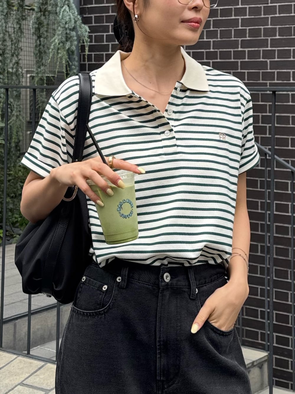 グリーン系のポロシャツ、ブラック系のデニムパンツ、ブラック系のパンプスを着用したレディースの夏コーディネートの4枚目の写真