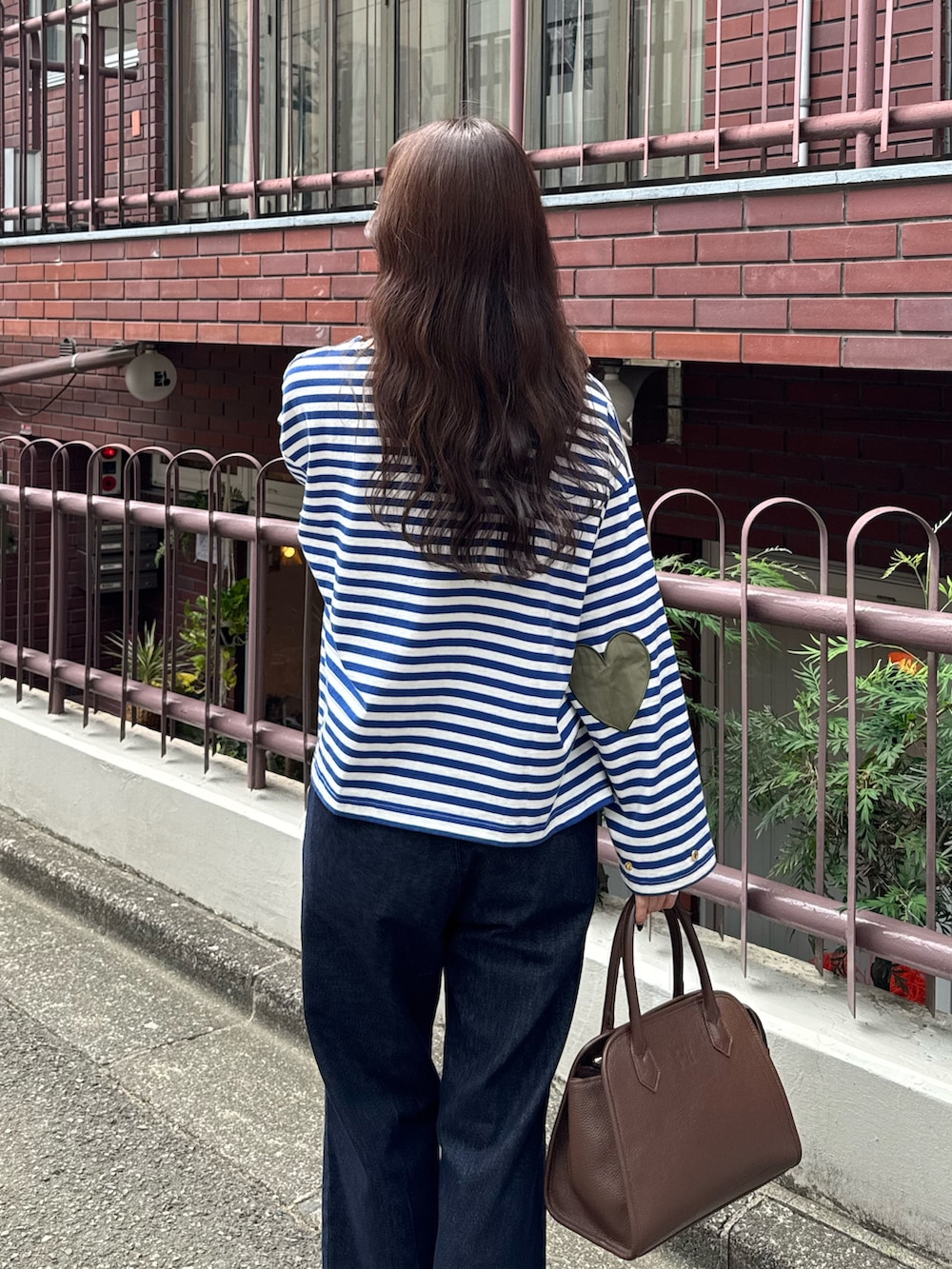 ブルー系のTシャツ/カットソー、ブルー系のデニムパンツ、ブラウン系のショルダーバッグを着用したレディースの夏コーディネートの4枚目の写真