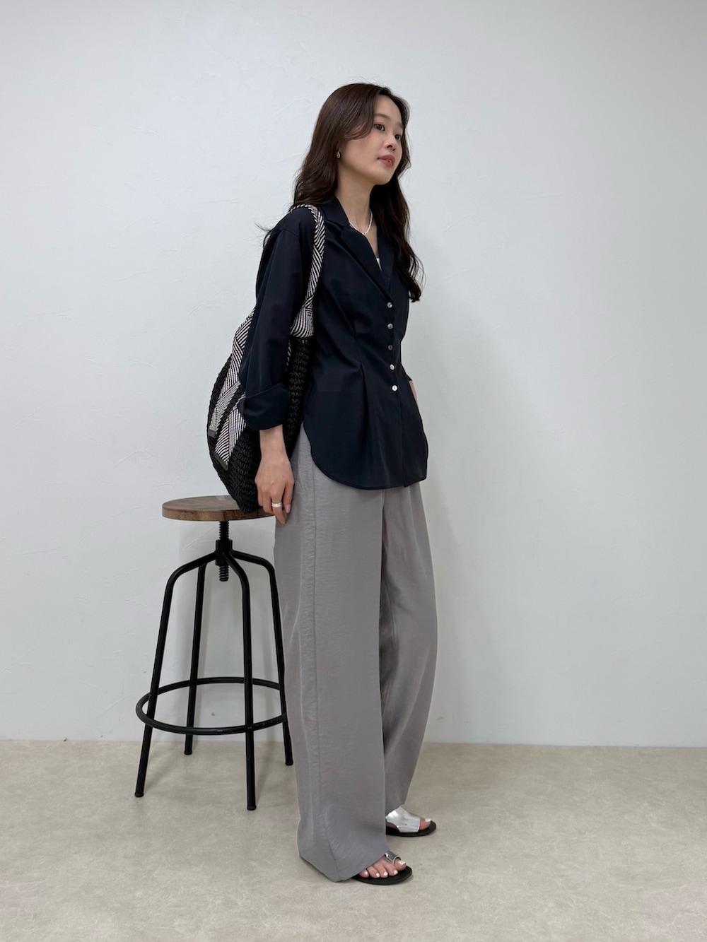 ブルー系のシャツ/ブラウス、グレー系のその他パンツ、ブラック系のトートバッグを着用したレディースの春コーディネートの2枚目の写真