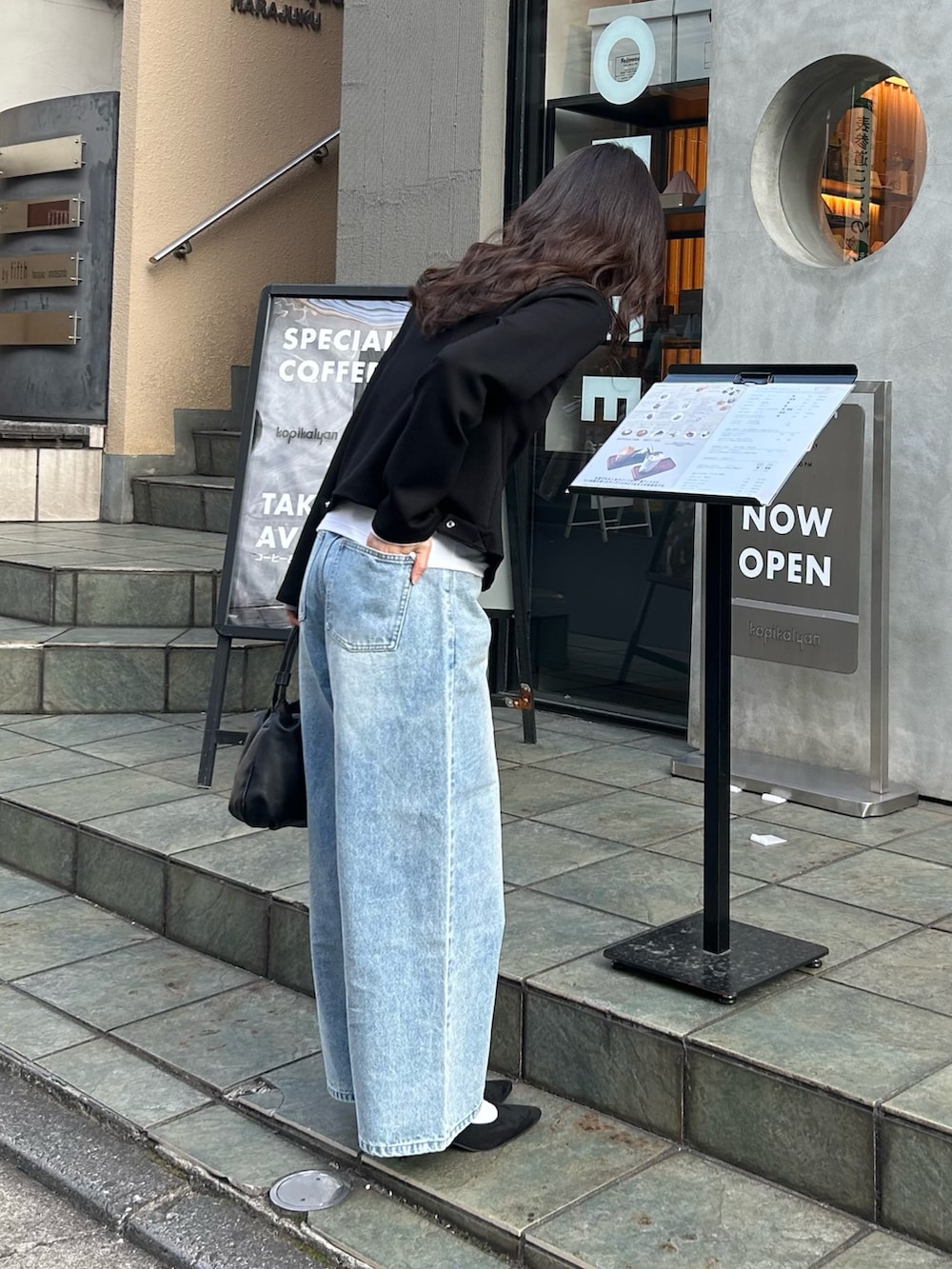 ブラック系のカーディガン/ボレロ、ブルー系のデニムパンツ、ブラック系のショルダーバッグを着用したレディースの春コーディネートの3枚目の写真