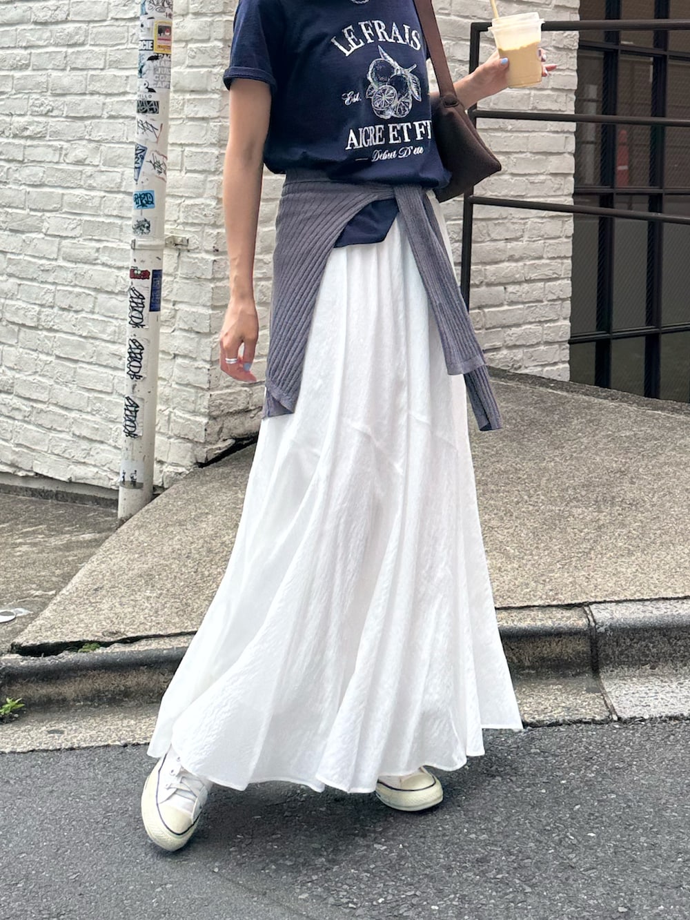 ブルー系のTシャツ/カットソー、ホワイト系のスカート、グレー系のキャップを着用したレディースの夏コーディネートの2枚目の写真