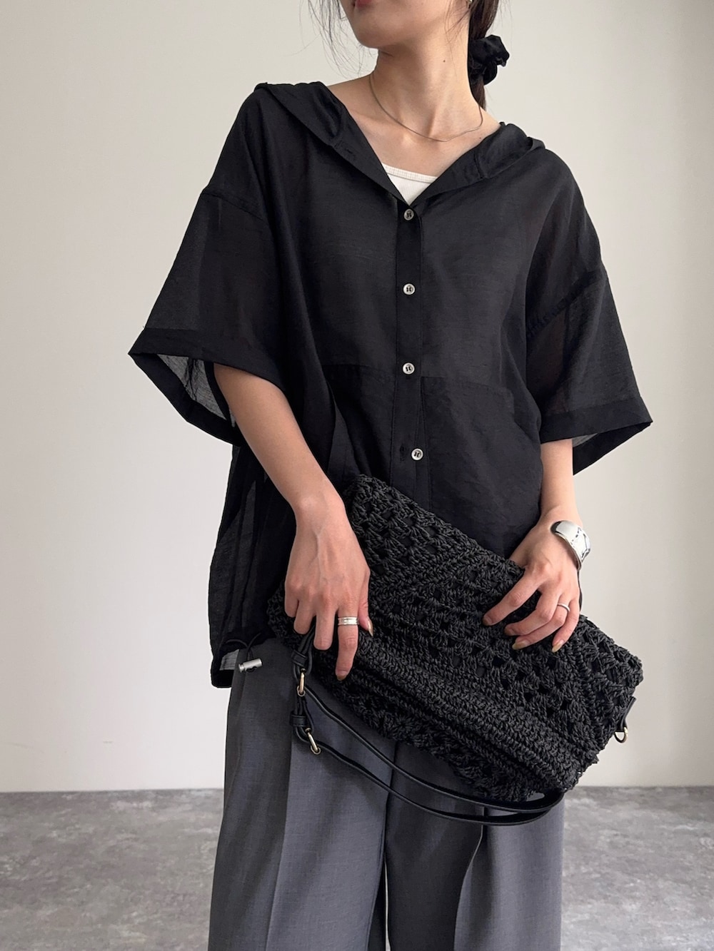 ブラック系のシャツ/ブラウス、グレー系のスラックス、ブラック系のかごバッグを着用したレディースの夏コーディネートの5枚目の写真