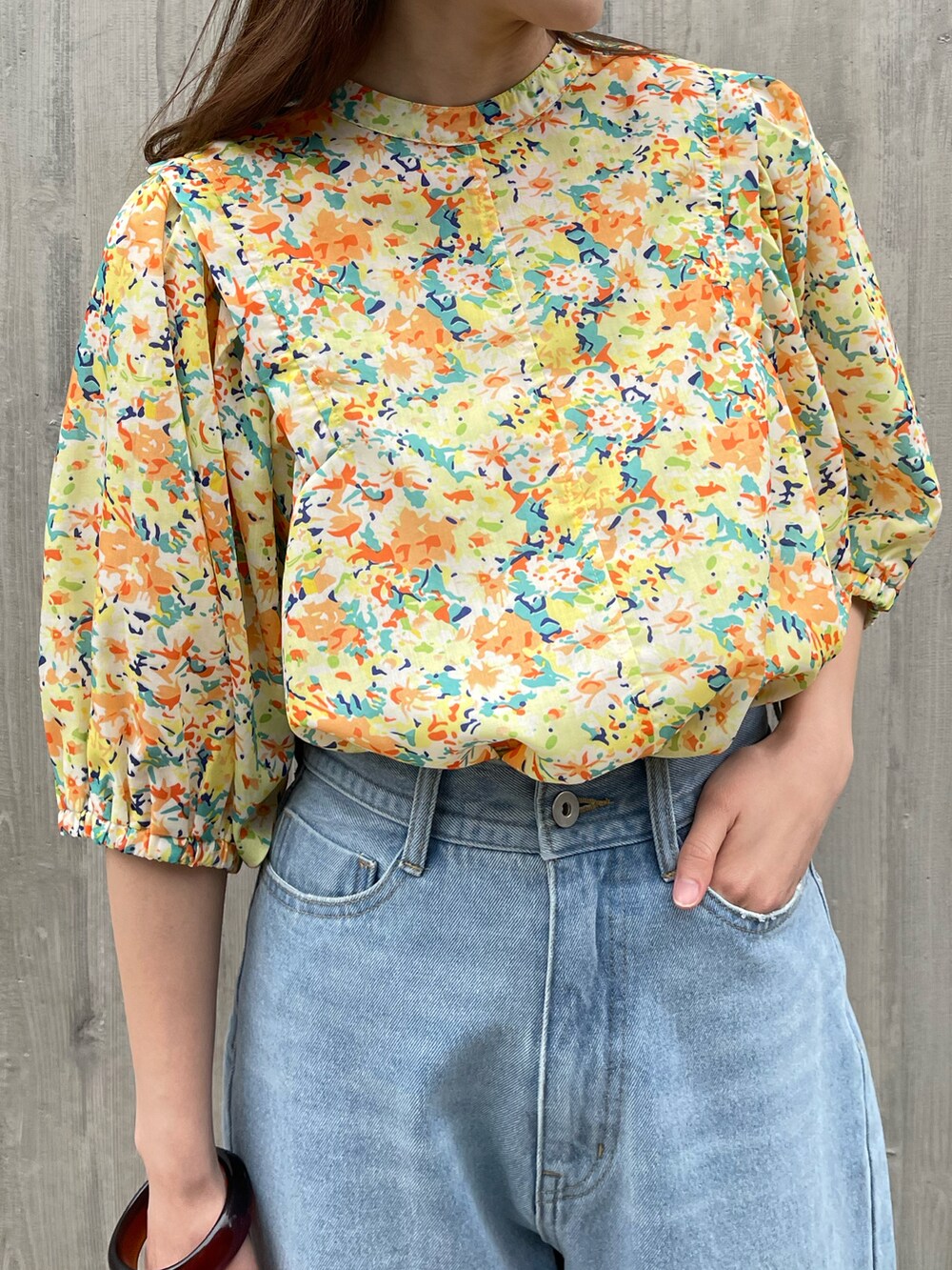 ブルー系のデニムパンツ、イエロー系のシャツ/ブラウス、オレンジ系のショルダーバッグを着用したレディースの春コーディネートの3枚目の写真