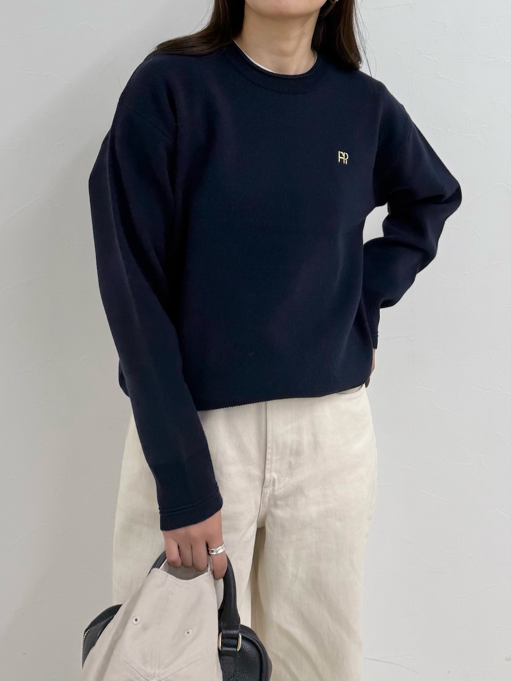 ブルー系のニット/セーター、ホワイト系のデニムパンツ、ホワイト系のキャップを着用したレディースの夏コーディネートの6枚目の写真