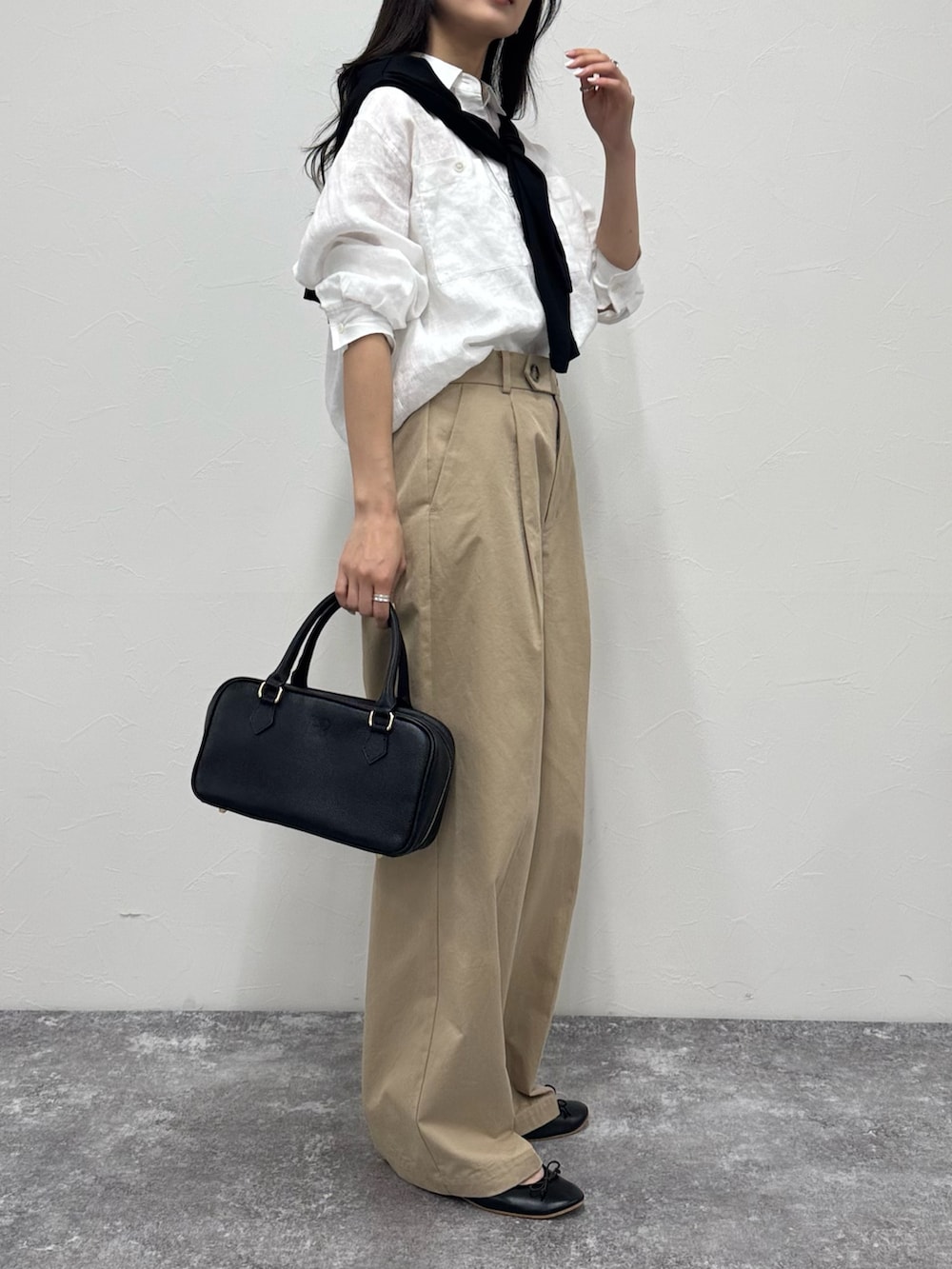 ホワイト系のシャツ/ブラウス、ベージュ系のチノパンツ、ブラック系のショルダーバッグを着用したレディースの春コーディネートの2枚目の写真