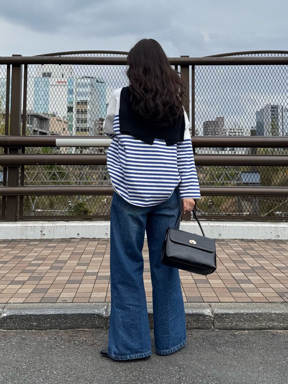 ブルー系のTシャツ/カットソー、ブルー系のデニムパンツ、ブラック系のカーディガン/ボレロを着用したレディースの春コーディネートの2枚目の写真