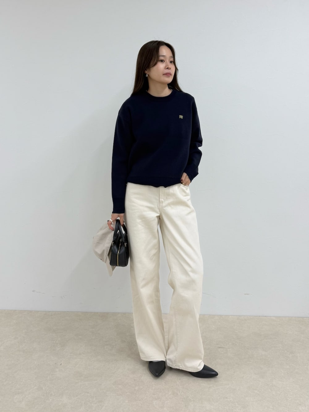 ブルー系のニット/セーター、ホワイト系のデニムパンツ、ホワイト系のキャップを着用したレディースの夏コーディネートの4枚目の写真