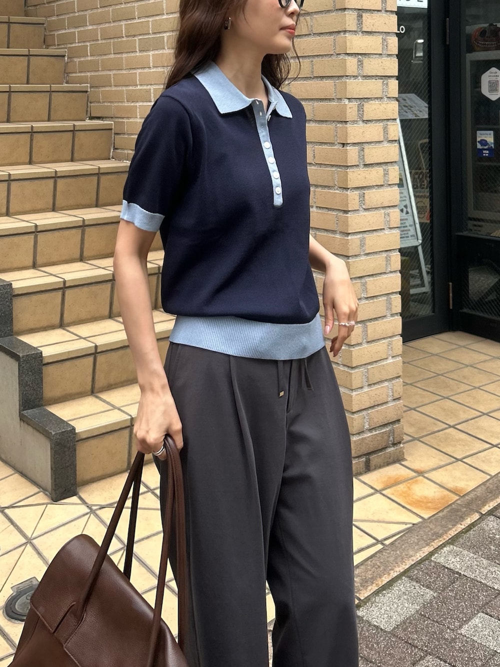ブルー系のニット/セーター、グレー系のその他パンツ、ブラウン系のショルダーバッグを着用したレディースの春コーディネートの3枚目の写真