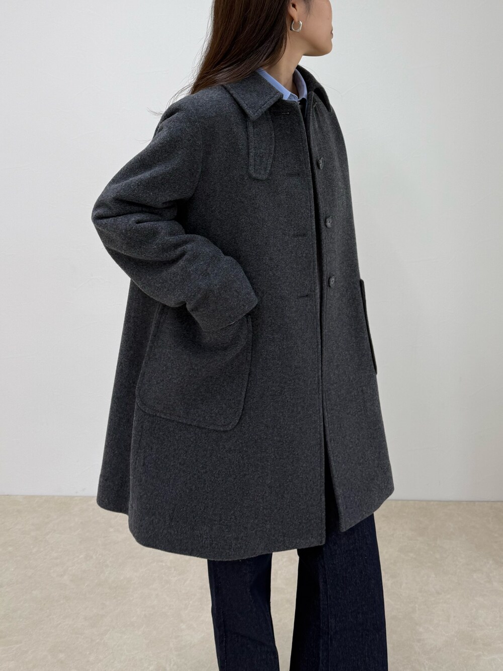 グレー系のダッフルコート、ブルー系のデニムパンツ、グレー系のニット/セーターを着用したレディースの秋コーディネートの4枚目の写真