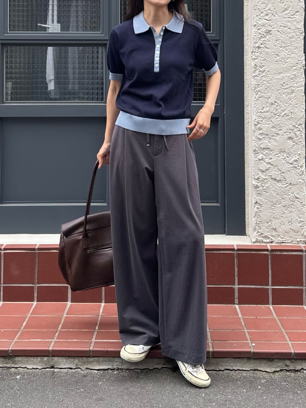 ブルー系のニット/セーター、グレー系のその他パンツ、ブラウン系のショルダーバッグを着用したレディースの春コーディネートの2枚目の写真