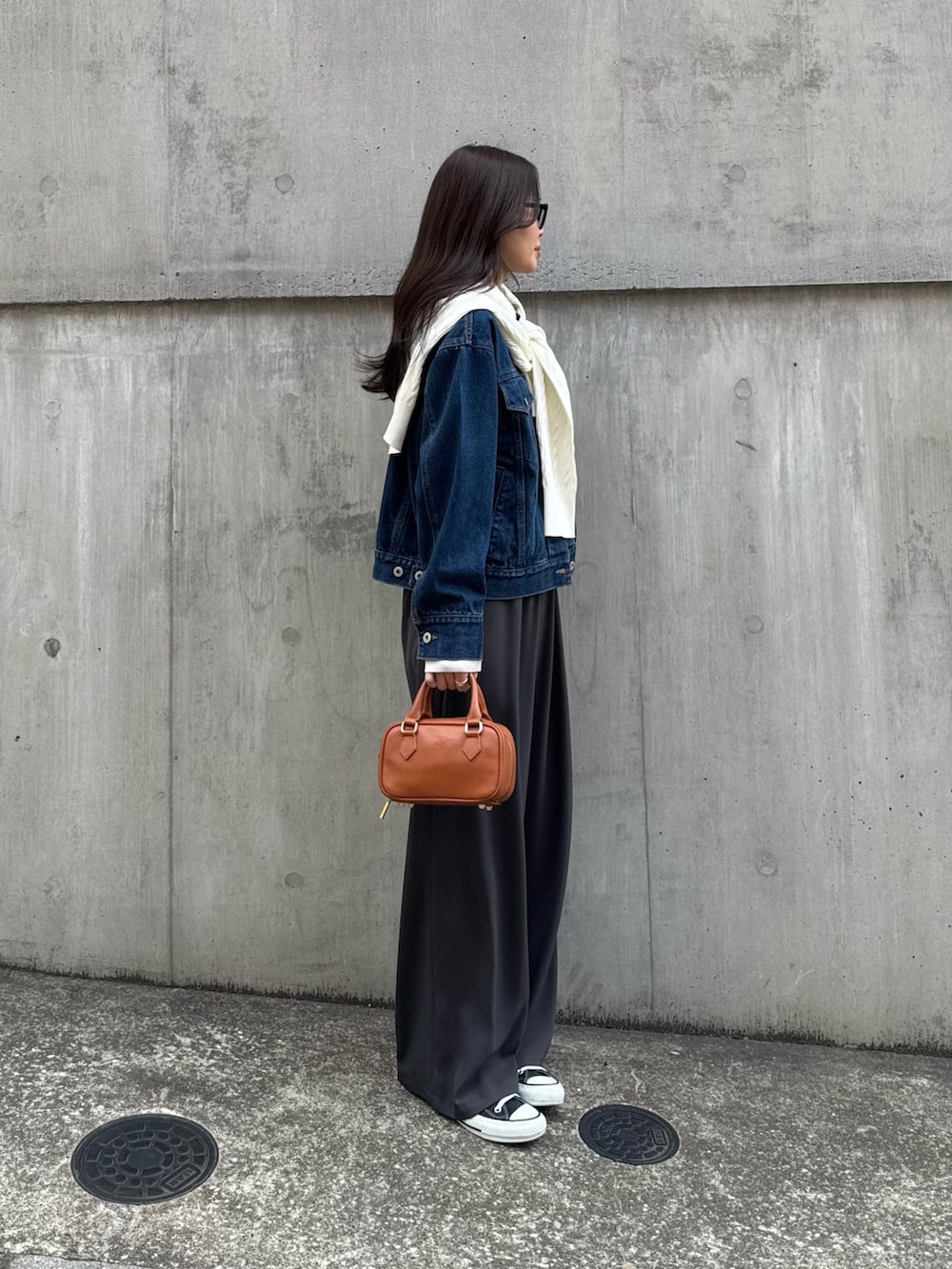 ブルー系のデニムジャケット、グレー系のその他パンツ、ホワイト系のカーディガン/ボレロを着用したレディースの春コーディネートの2枚目の写真