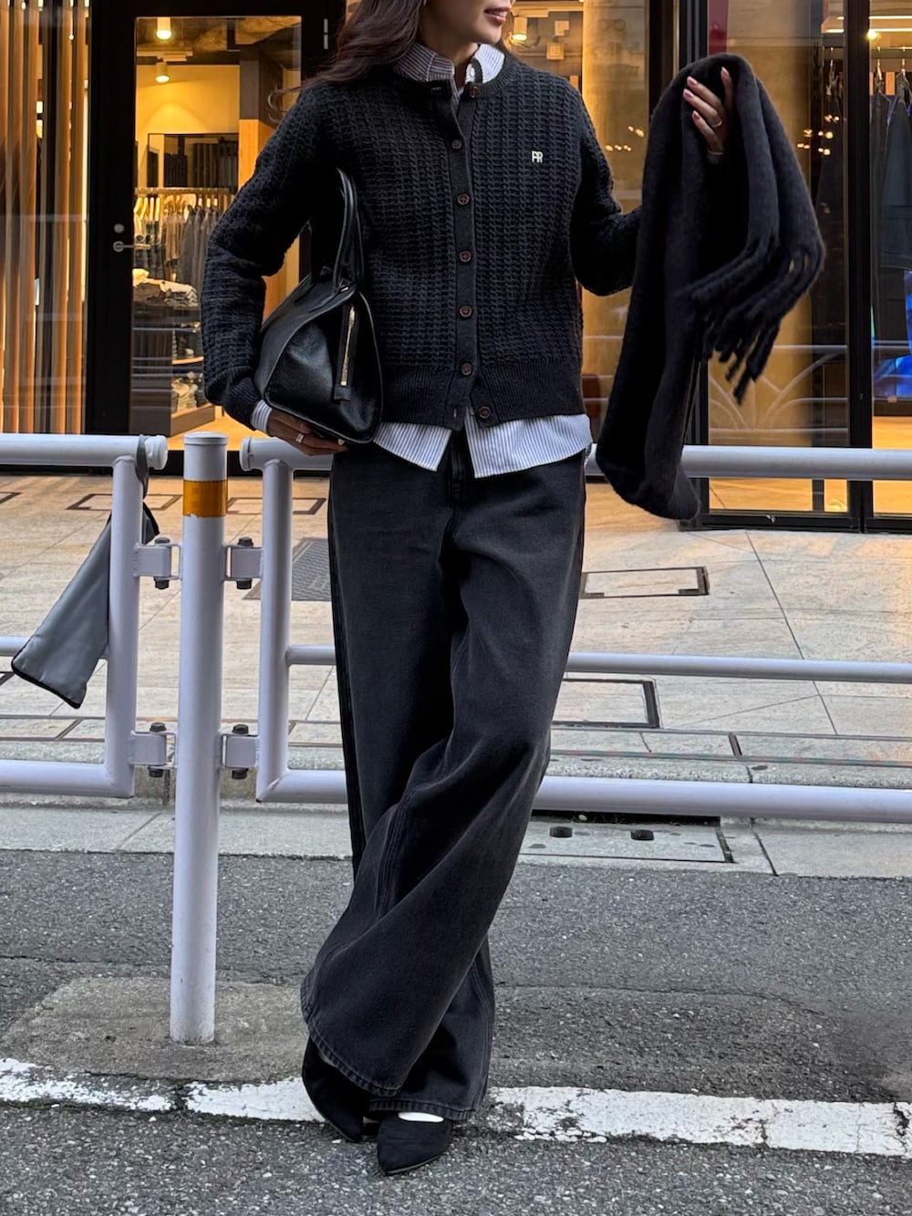 グレー系のニット/セーター、ブラック系のデニムパンツを着用したレディースの秋コーディネートの2枚目の写真