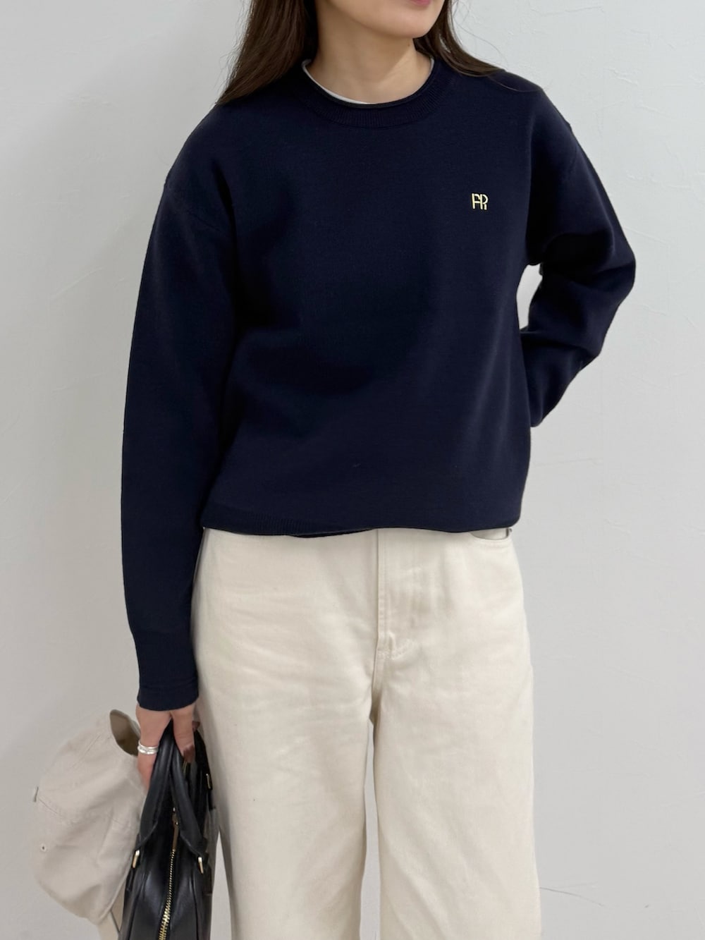 ブルー系のニット/セーター、ホワイト系のデニムパンツ、ホワイト系のキャップを着用したレディースの夏コーディネートの5枚目の写真