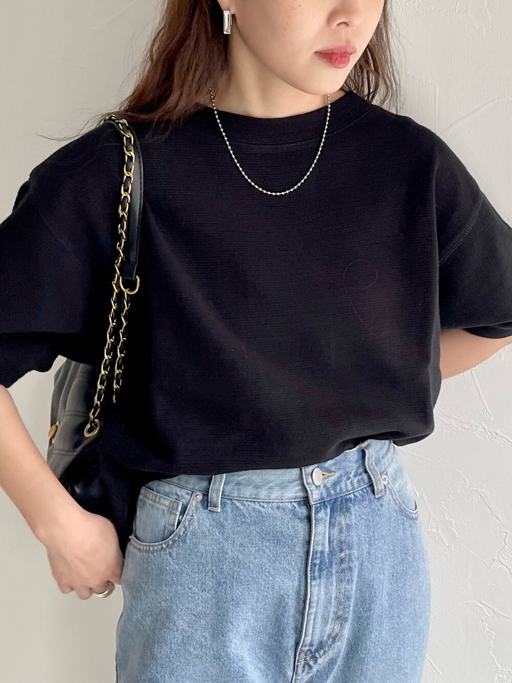 ブラック系のTシャツ/カットソー、ブルー系のデニムパンツを着用したレディースの春コーディネートの2枚目の写真