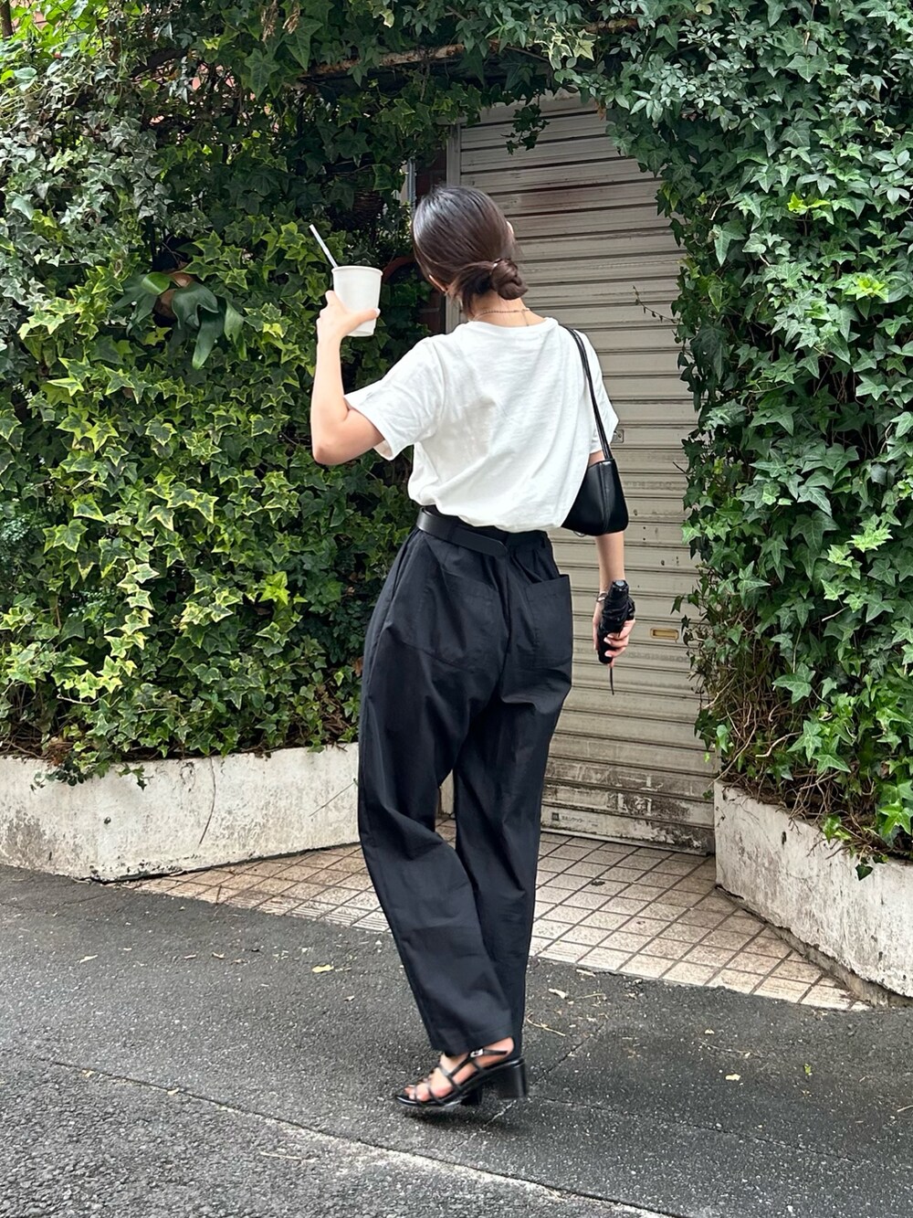 ホワイト系のTシャツ/カットソー、ブラック系のその他パンツ、ブラック系のハンドバッグを着用したレディースの夏コーディネートの2枚目の写真