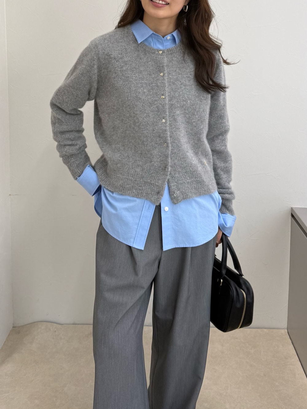グレー系のカーディガン/ボレロ、ブルー系のシャツ/ブラウス、ブラック系のボストンバッグを着用したレディースの秋コーディネートの5枚目の写真