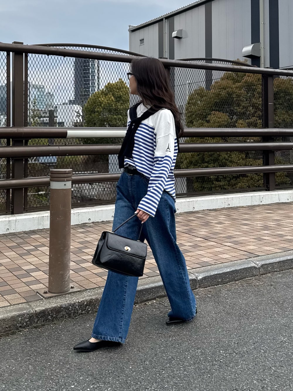 ブルー系のTシャツ/カットソー、ブルー系のデニムパンツ、ブラック系のカーディガン/ボレロを着用したレディースの春コーディネートの4枚目の写真