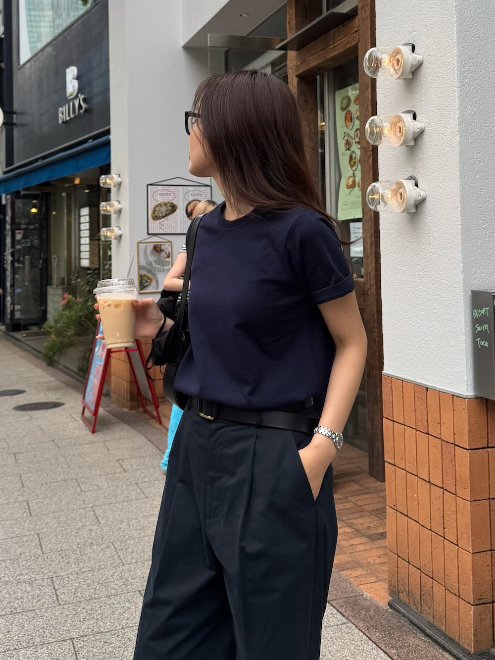 ブルー系のTシャツ/カットソー、ブルー系のチノパンツ、ブラック系のショルダーバッグを着用したレディースの春コーディネートの2枚目の写真