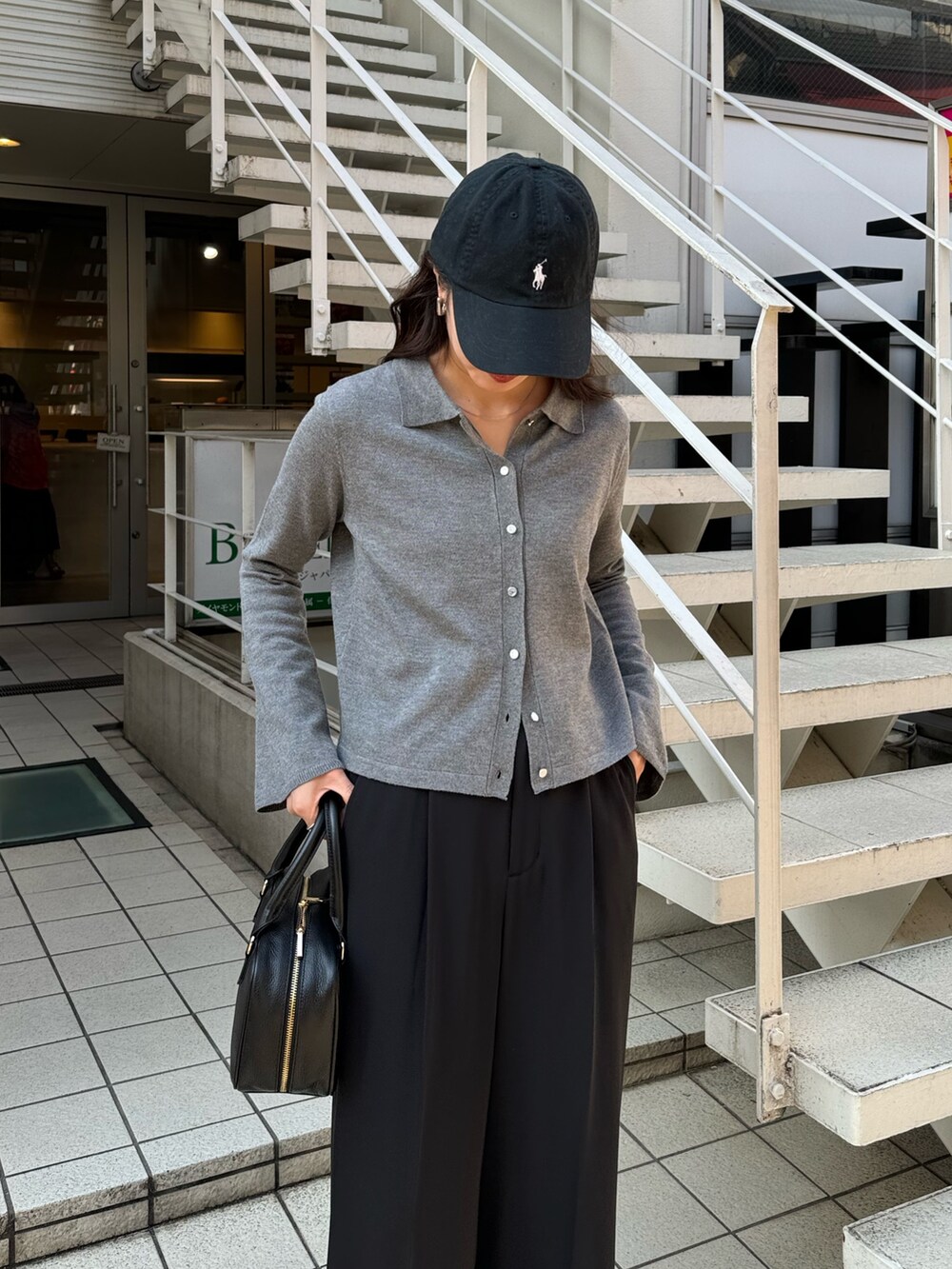 グレー系のカーディガン/ボレロ、ブラック系のスラックス、ブラック系のハンドバッグを着用したレディースの冬コーディネートの3枚目の写真