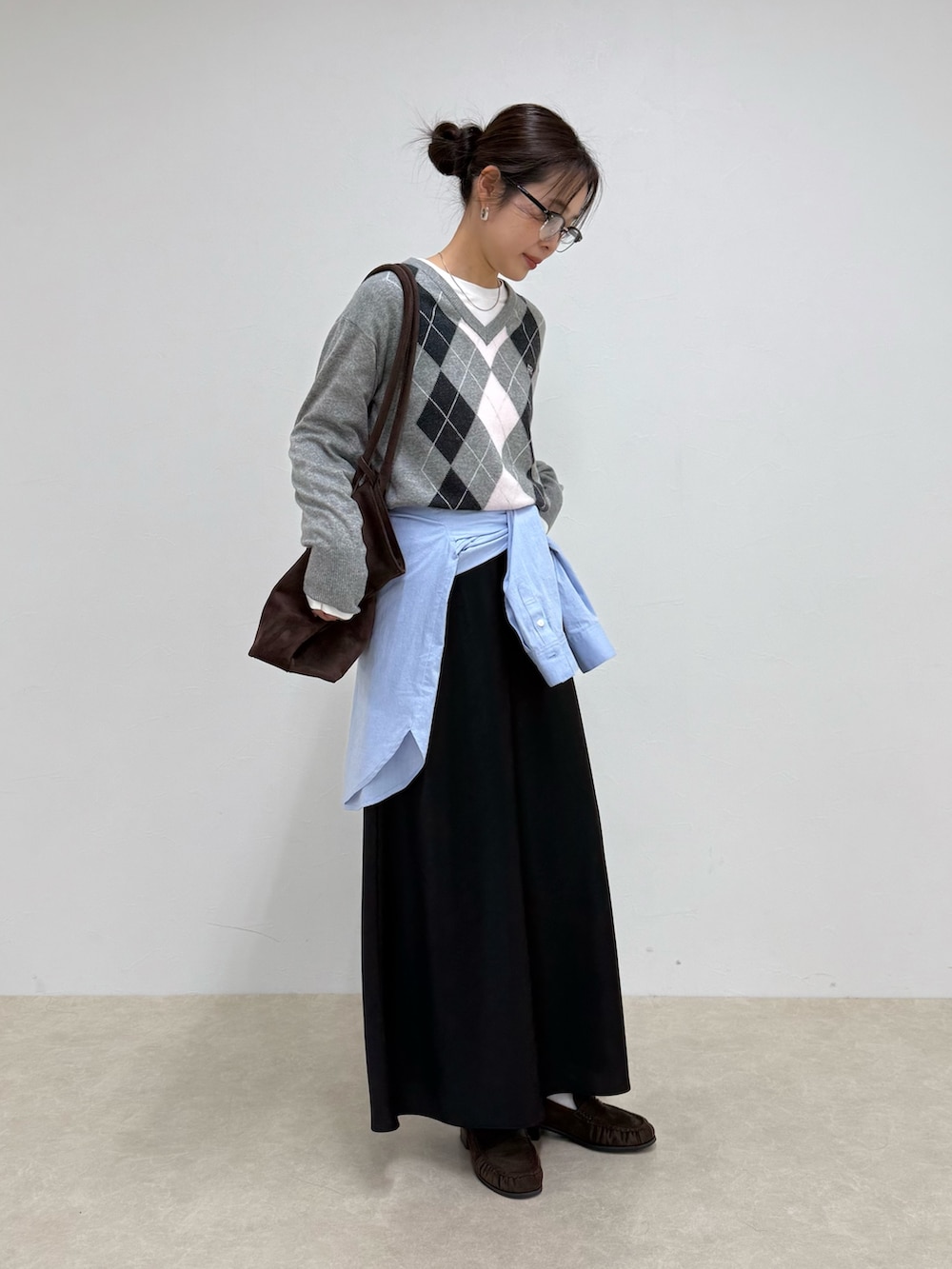 グレー系のニット/セーター、ブラック系のスカートを着用したレディースの冬コーディネートの3枚目の写真